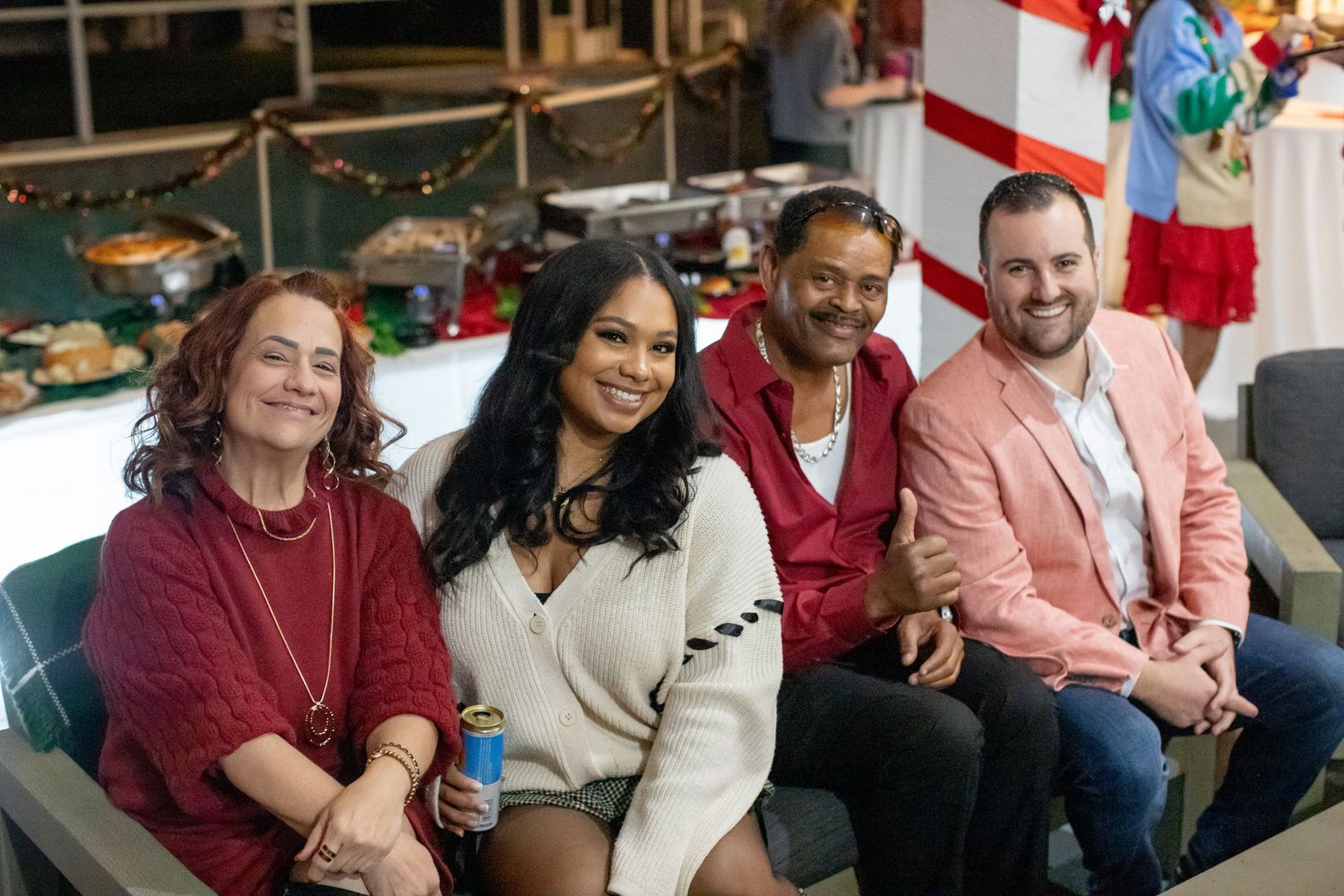Group of friends sitting together on couch during holiday celebration.