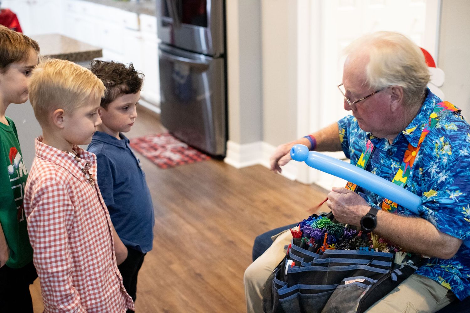 People gathered indoors opening presents and celebrating during a holiday party.