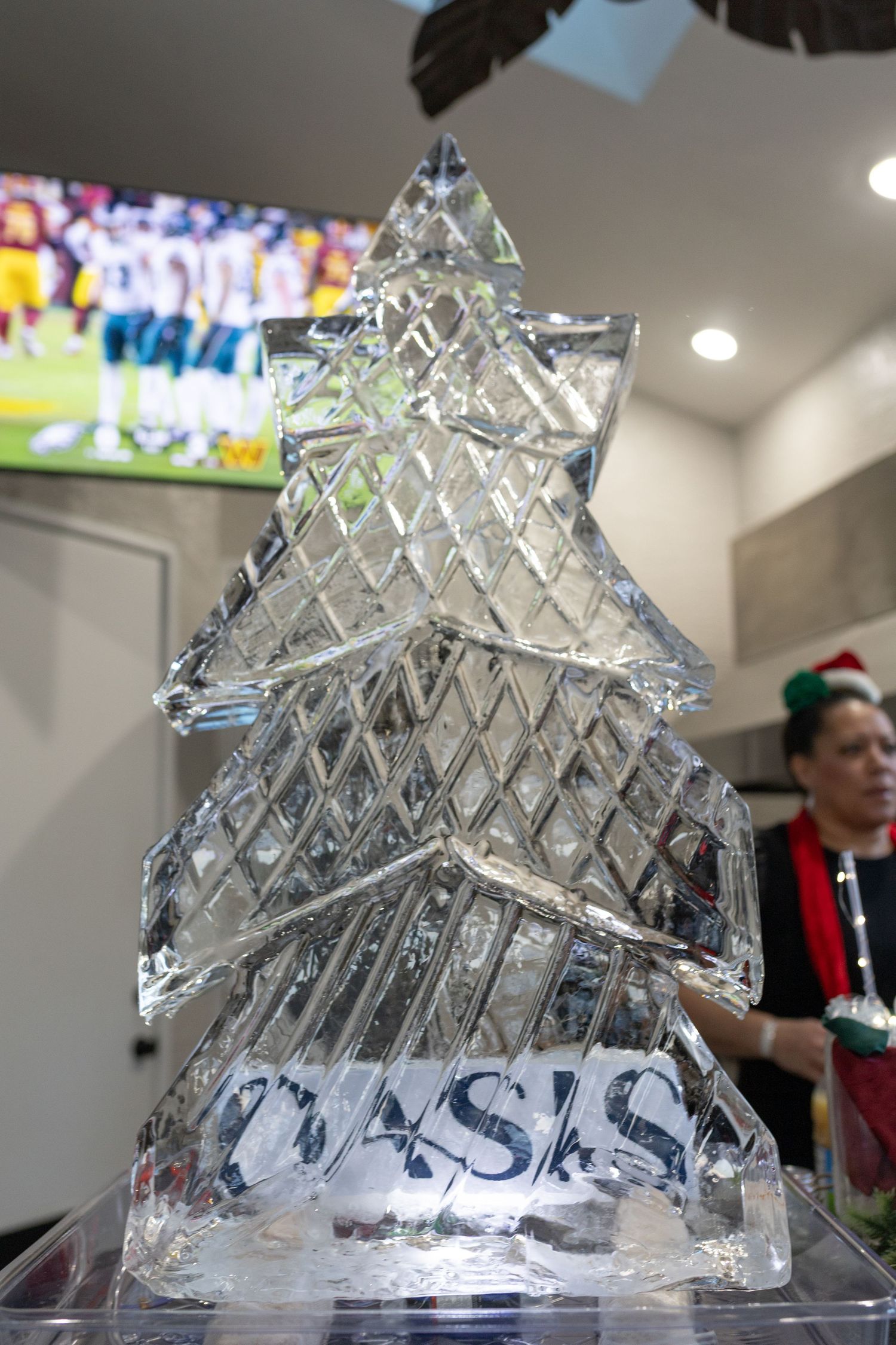 Intricate ice sculpture with geometric pyramid design displayed at an indoor event.
