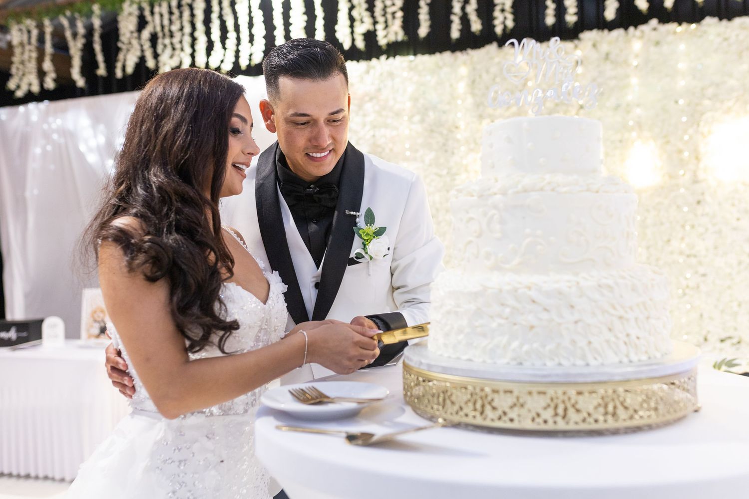 Elegant wedding reception setup with white decor and hanging string lights creating a romantic atmosphere.