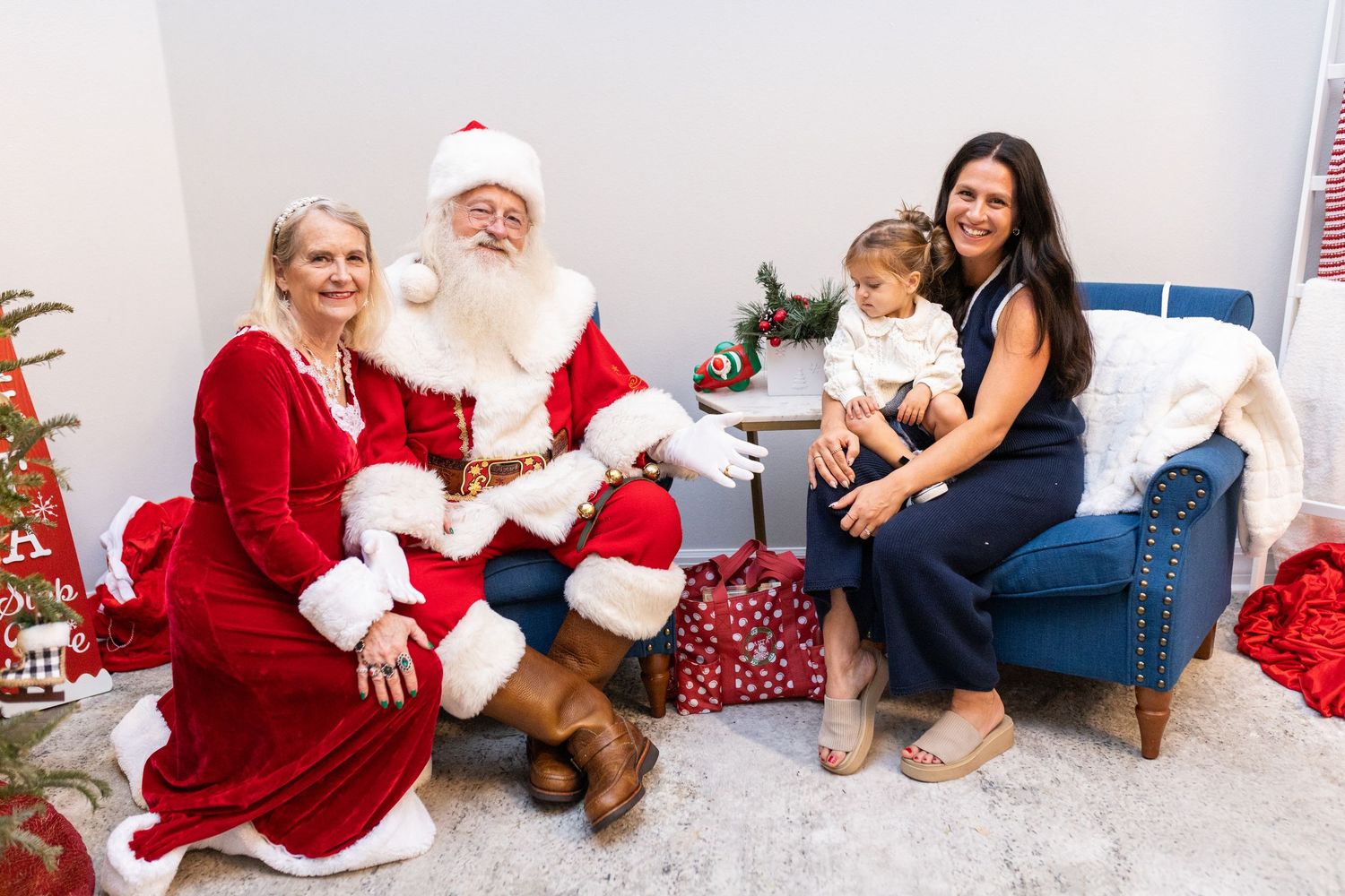 Holiday photo session with Santa and children in a bright studio setting with festive decorations.
