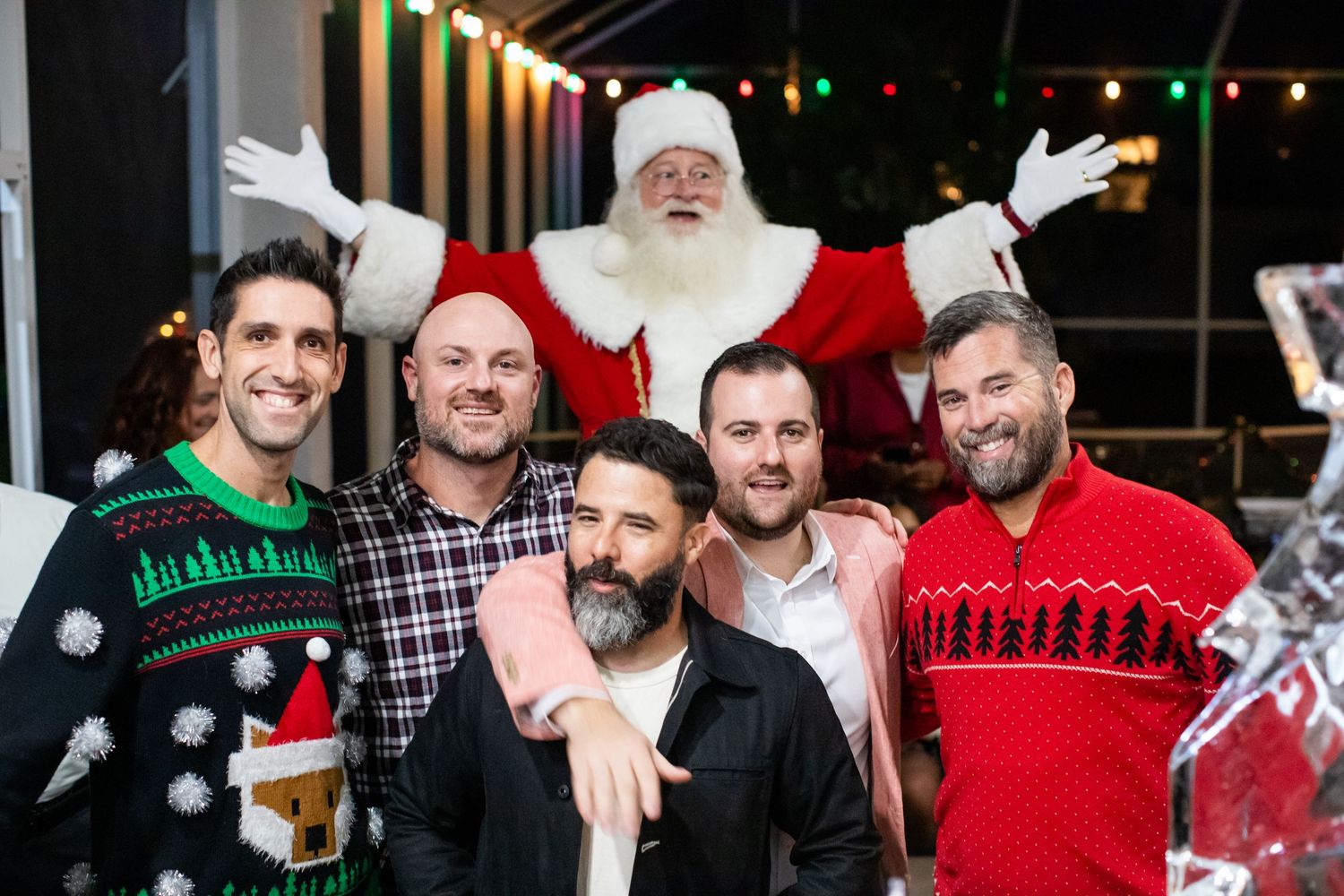 Friends enjoying drinks and holiday festivities at a nighttime bar gathering.