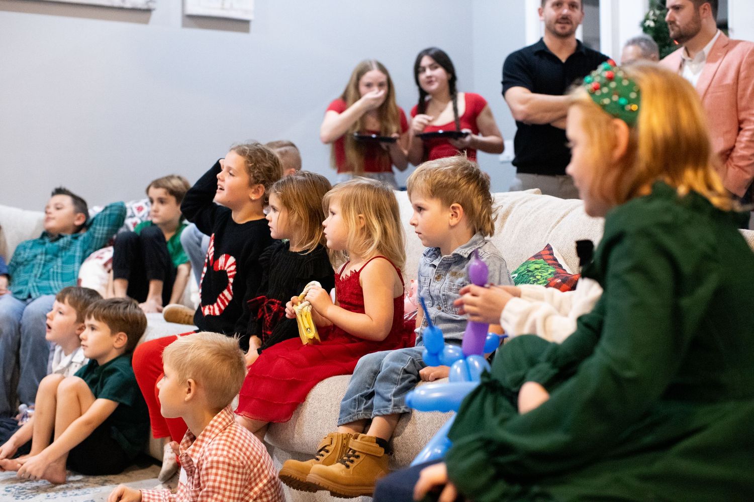 Group of people gathered for a holiday celebration in a bright indoor space.
