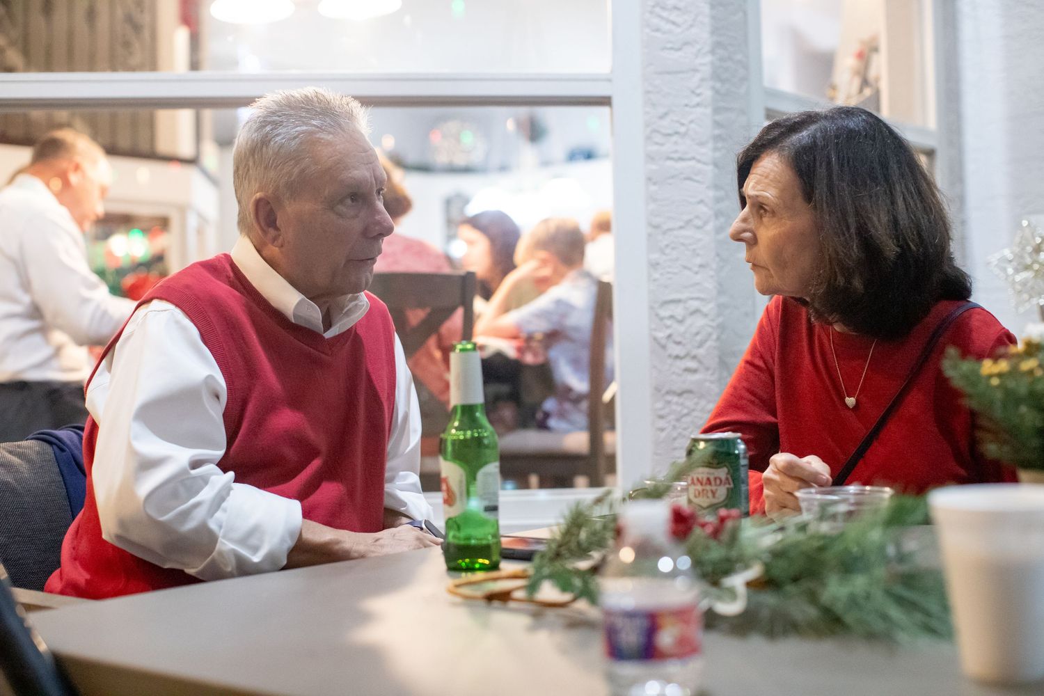 People gathered around tables in a dining area wearing red and white attire.