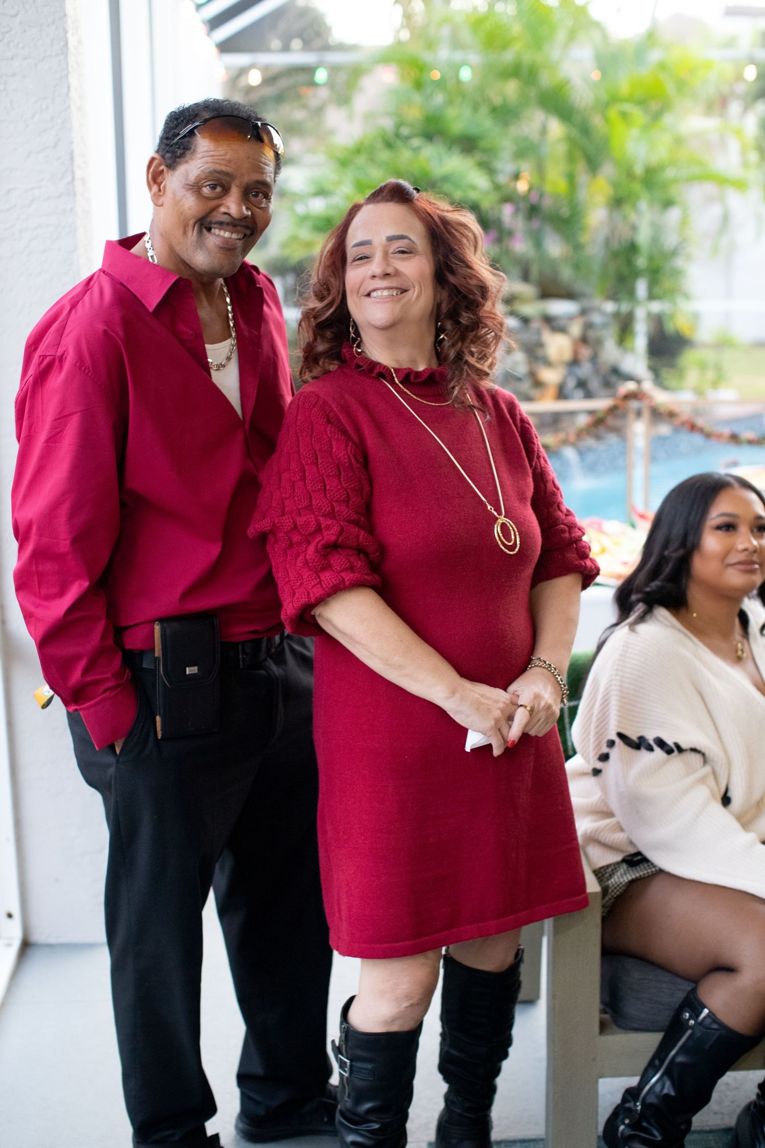Group wearing matching burgundy outfits posing together at a celebration.