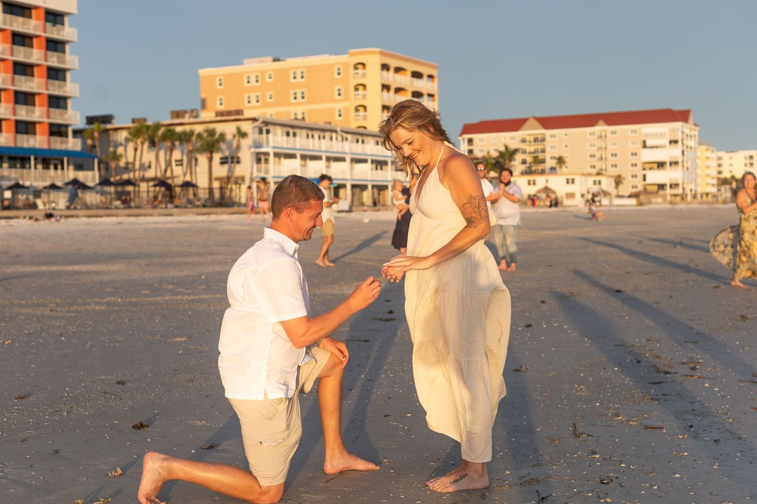 A beachside marriage proposal sequence with coastal buildings in the background.