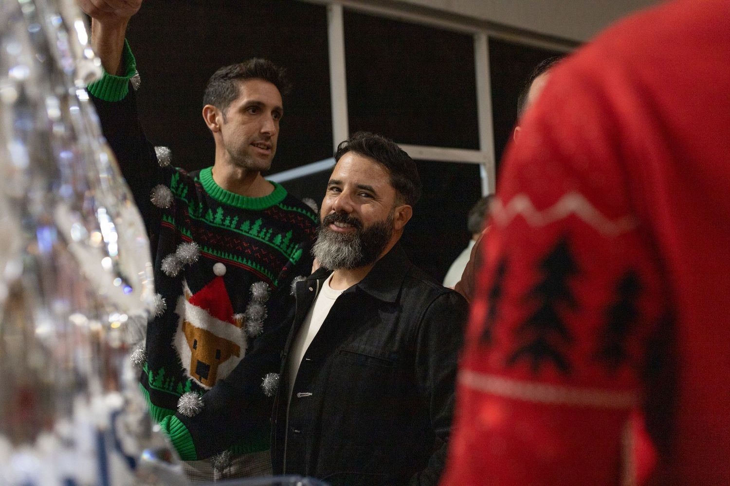 A blurred candid shot of people mingling at a holiday party.