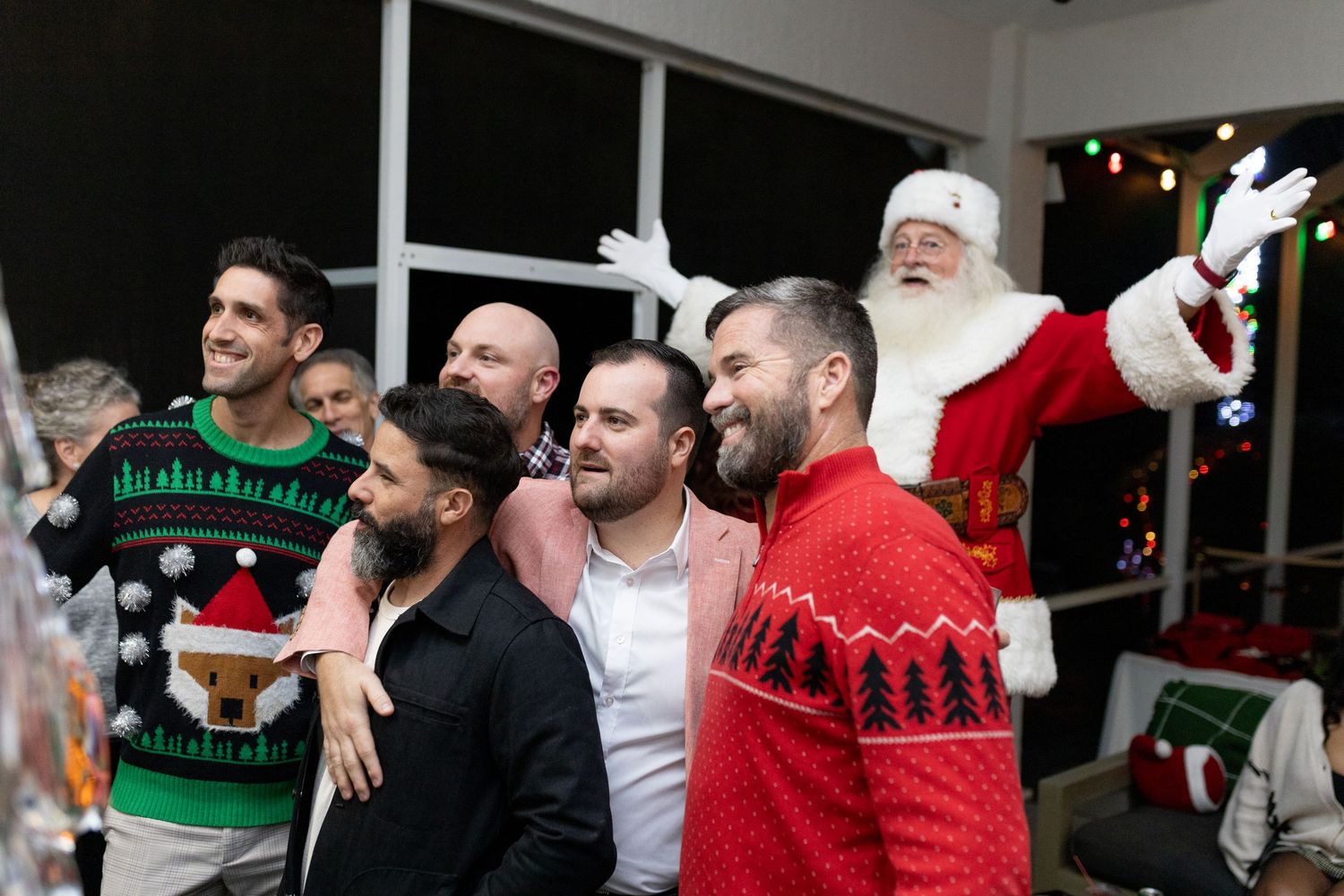 Holiday party scene with people in Christmas sweaters and Santa spreading cheer.