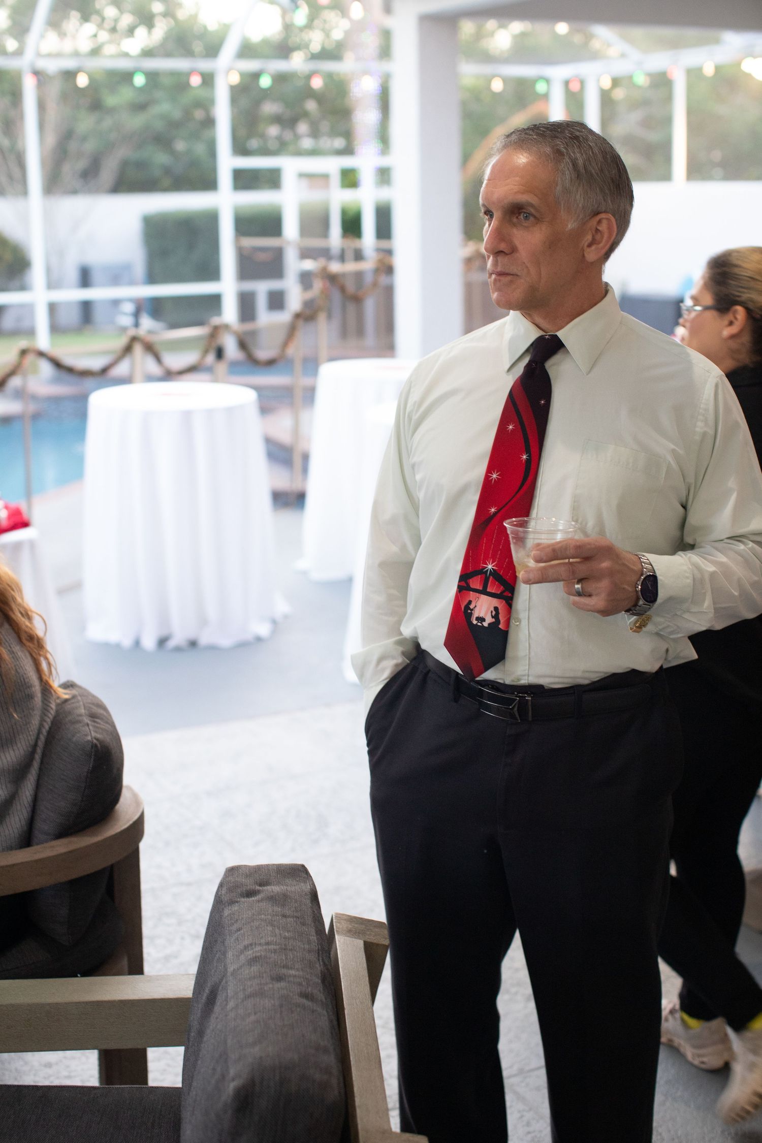 People in formal attire mingling at an indoor reception area.