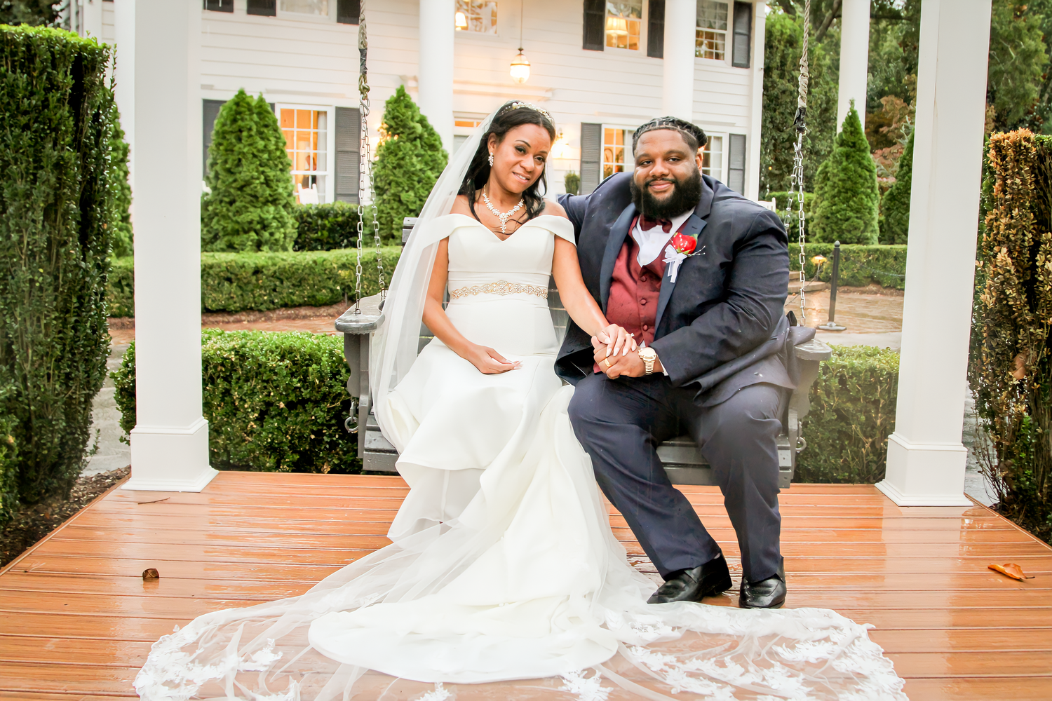 Romantic wedding portraits captured on a brick porch with white colonial columns.
