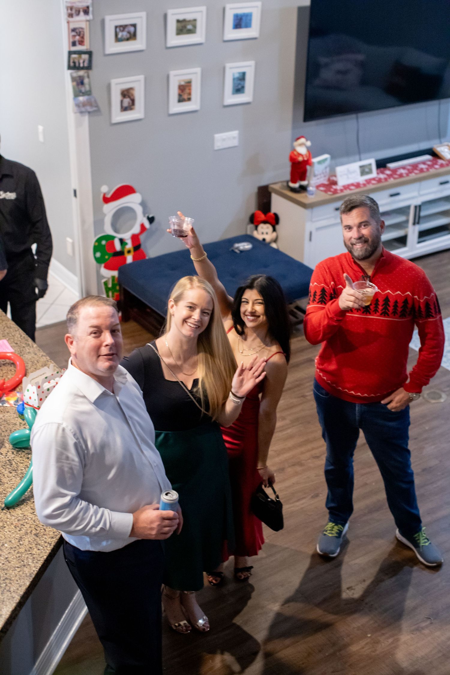 Holiday party guests celebrating in a gallery space with artwork on walls.