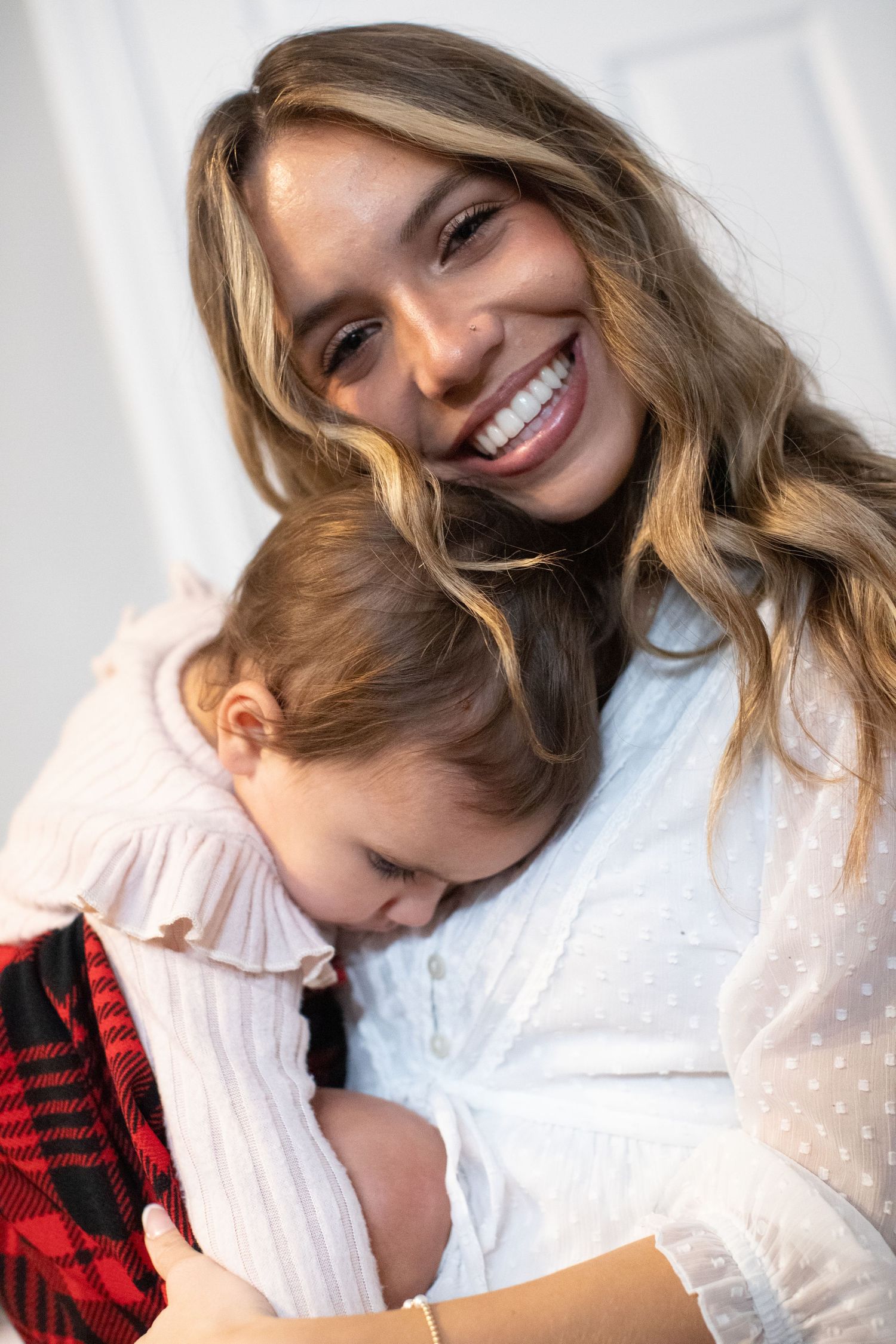 Intimate indoor portrait showing tender moments against a white background.