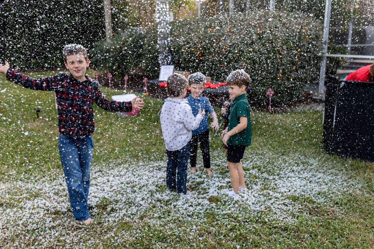 Artificial snow falling on party guests during outdoor winter celebration.