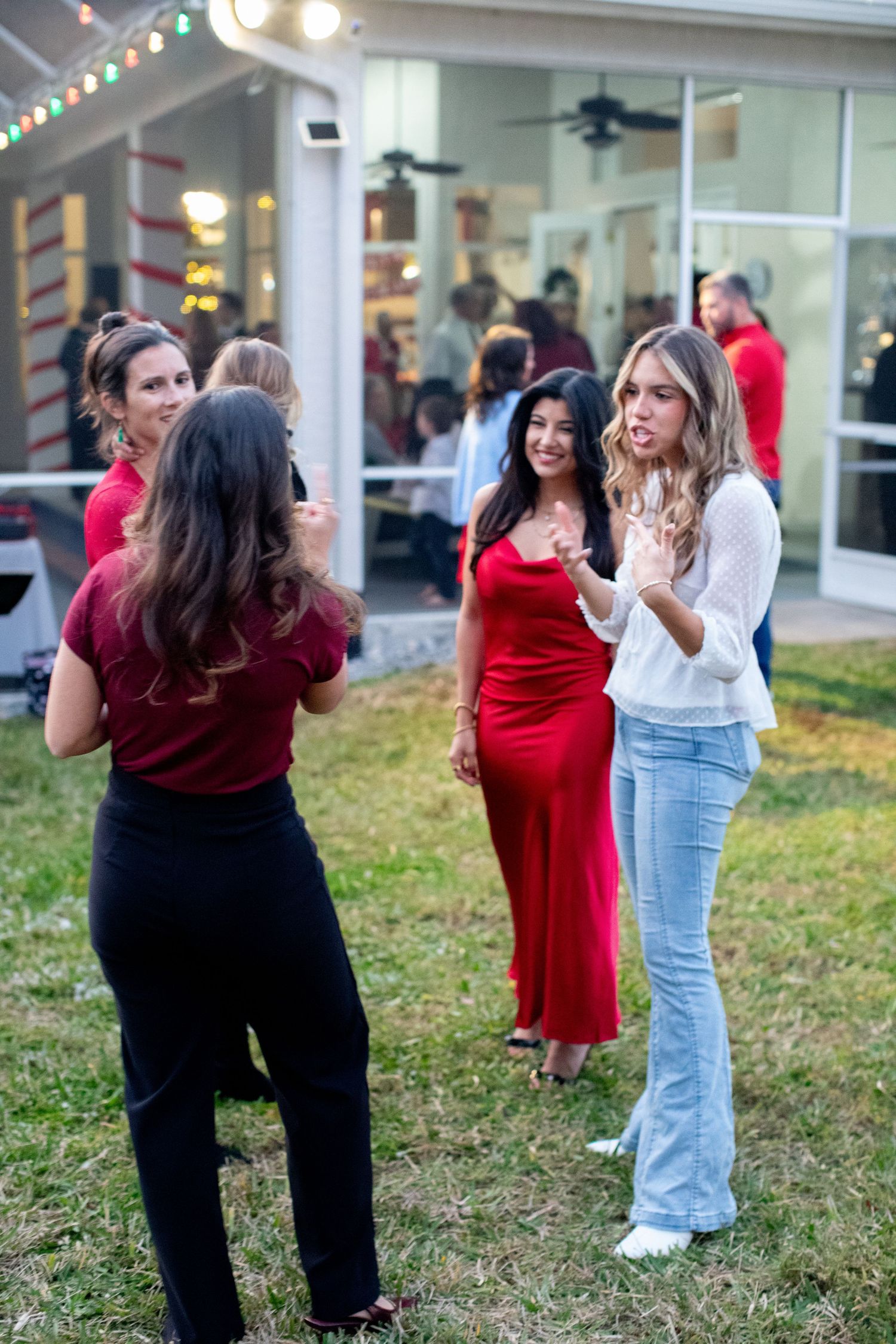 Group of friends gathered outdoors wearing red and black outfits for holiday celebrations.