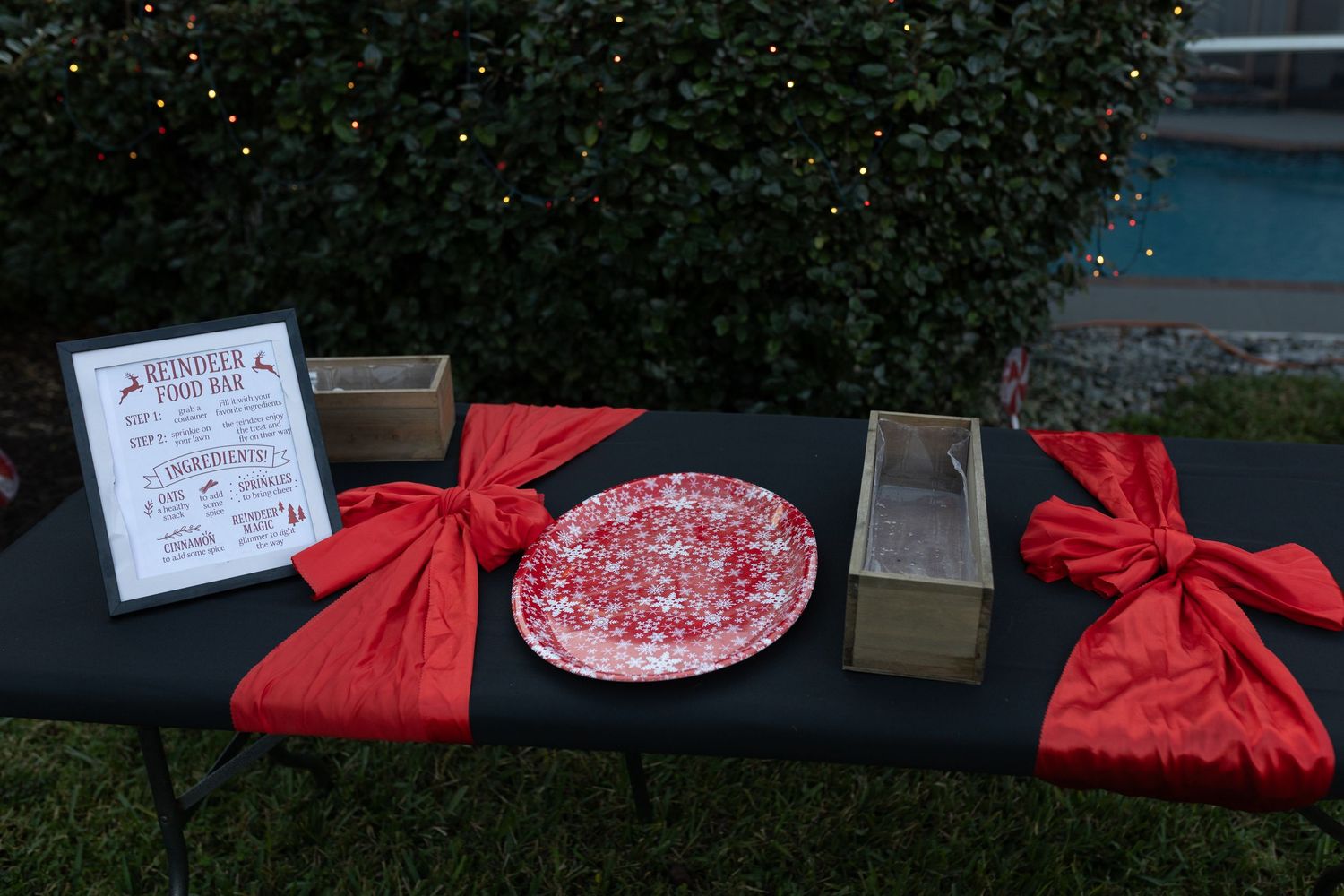 Red holiday decorations and gift boxes displayed on a dark surface.