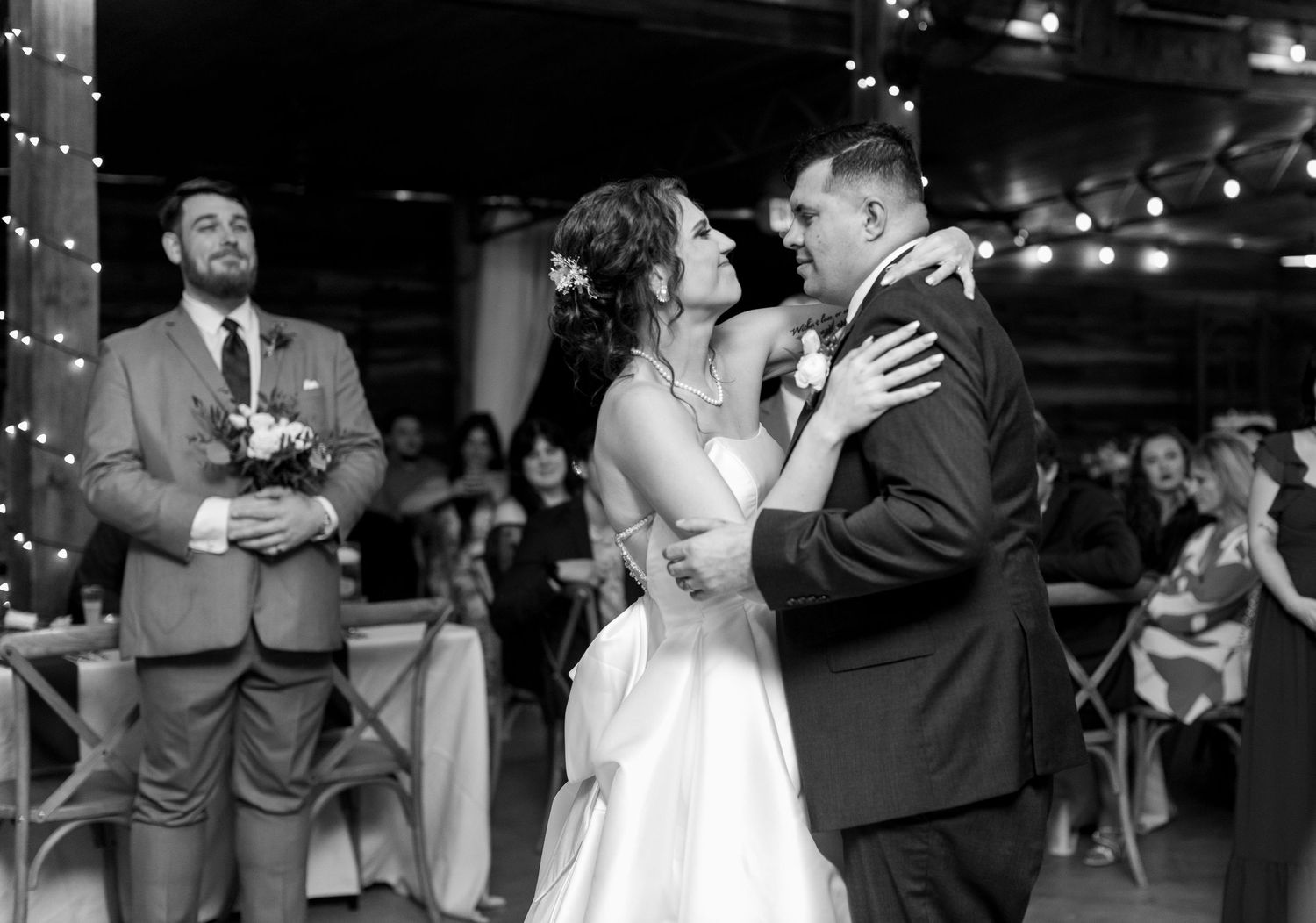 Wedding reception dance floor scene with string lights creating a romantic atmosphere.