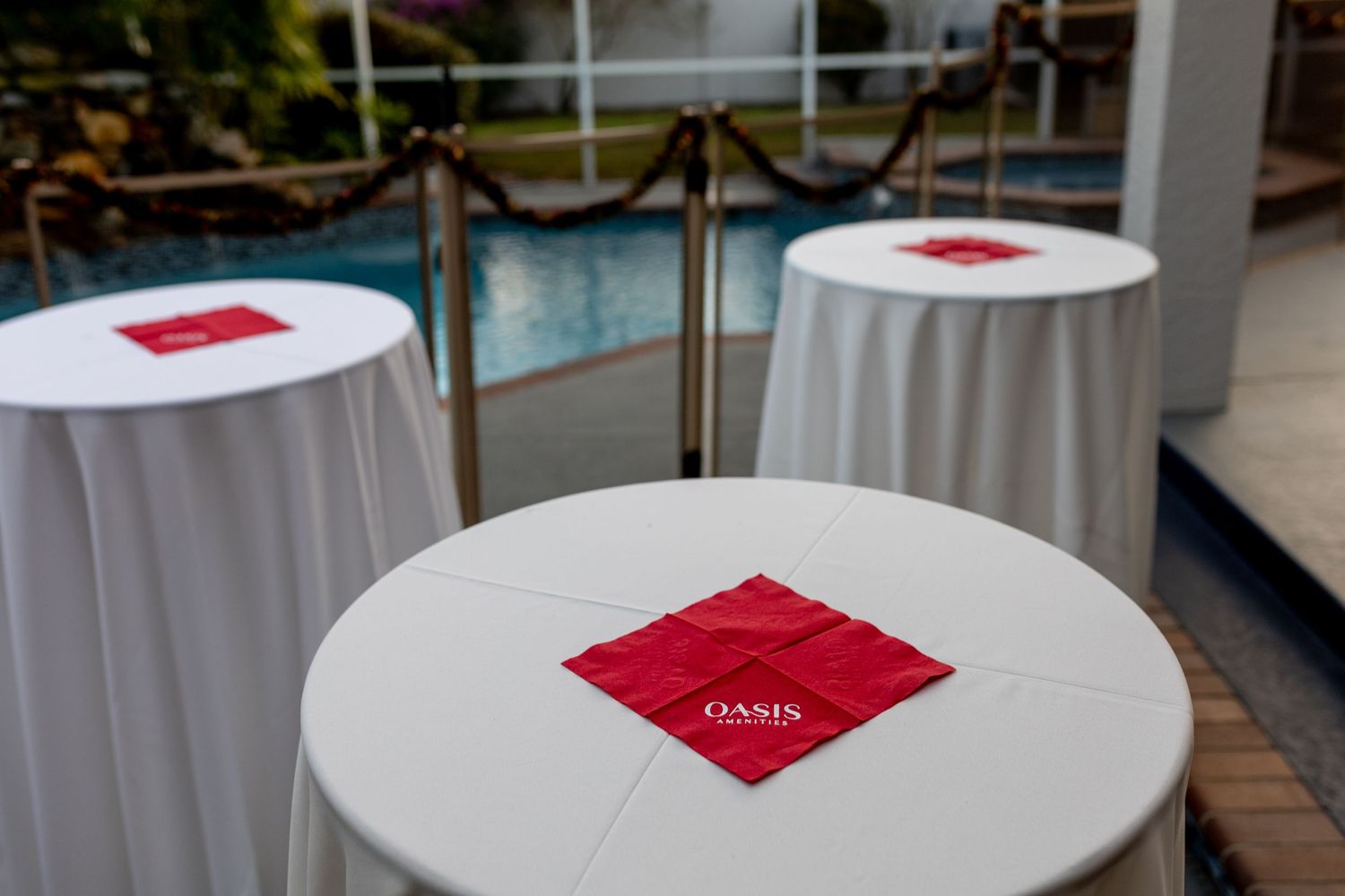 White round tables with red napkins set up for a formal event.