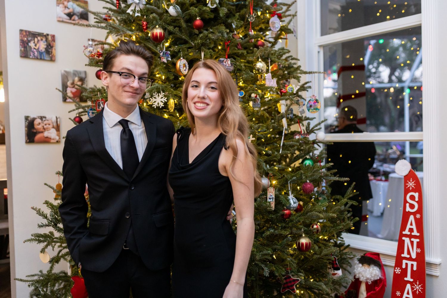 Festive holiday photos in front of a decorated Christmas tree with red and gold ornaments.