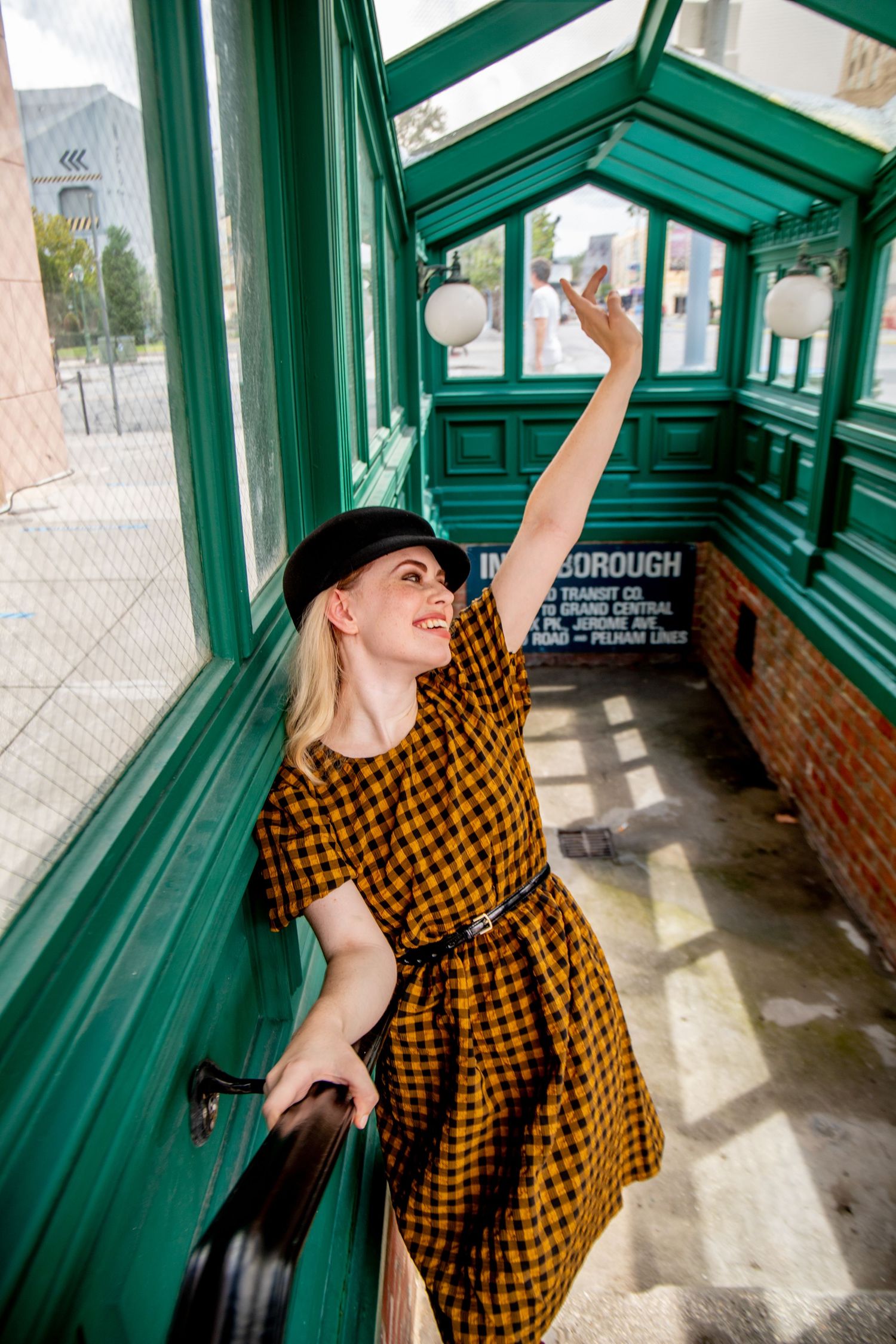 Interior photoshoot in green-framed corridor with natural lighting and brick walls.
