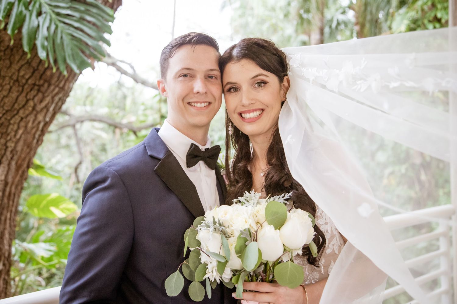 A romantic wedding portrait sequence with white flowers and flowing veil in a garden setting.
