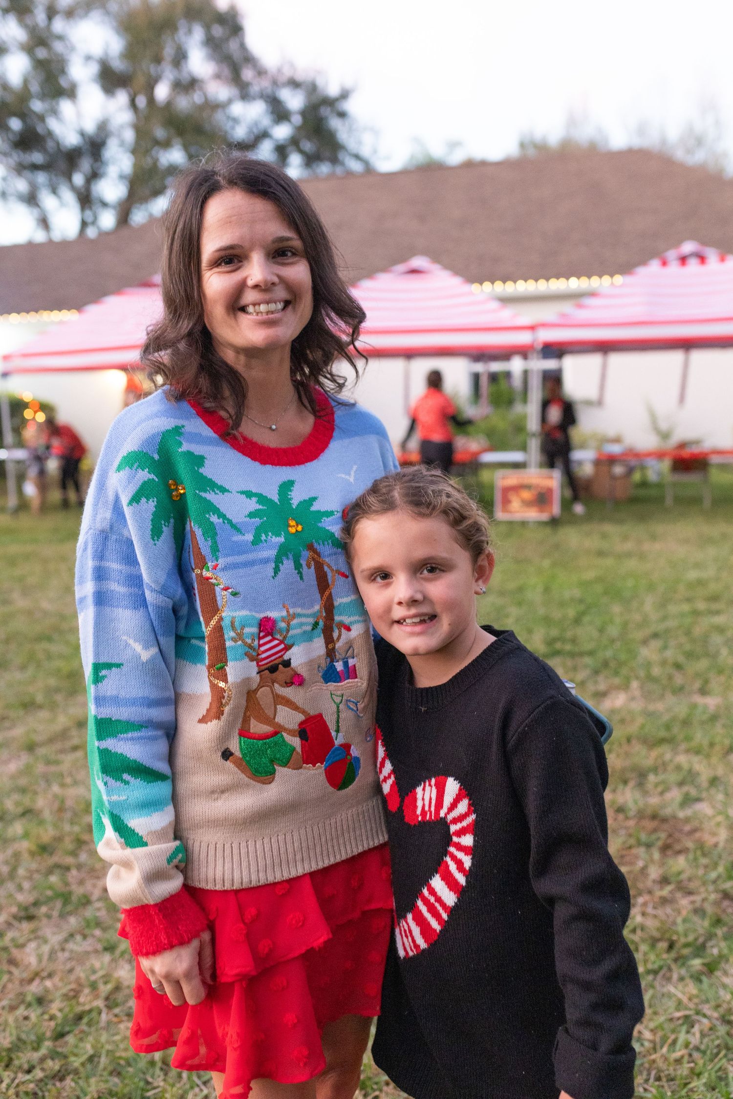 Holiday celebration with festive Christmas sweaters featuring palm trees and seasonal designs.