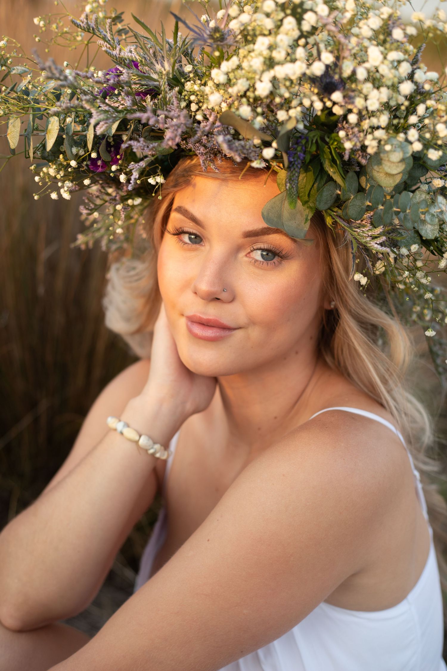 Romantic portrait featuring delicate white floral crown and natural makeup.
