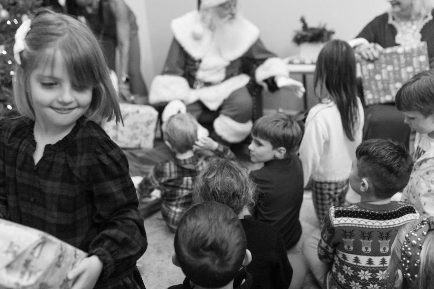 Holiday party scene with children gathered around festive decorations.