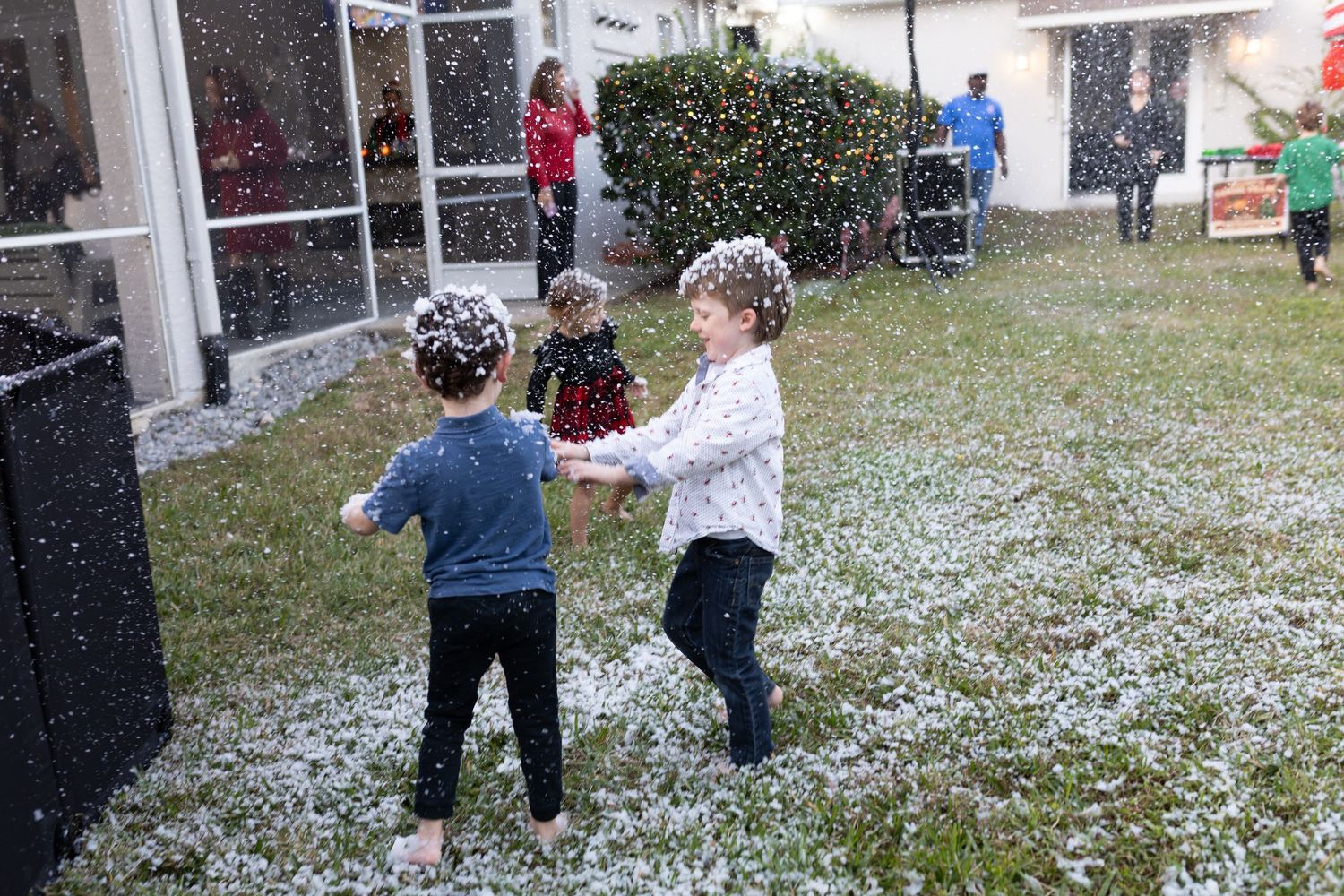 People playing in falling snow at an outdoor winter event.