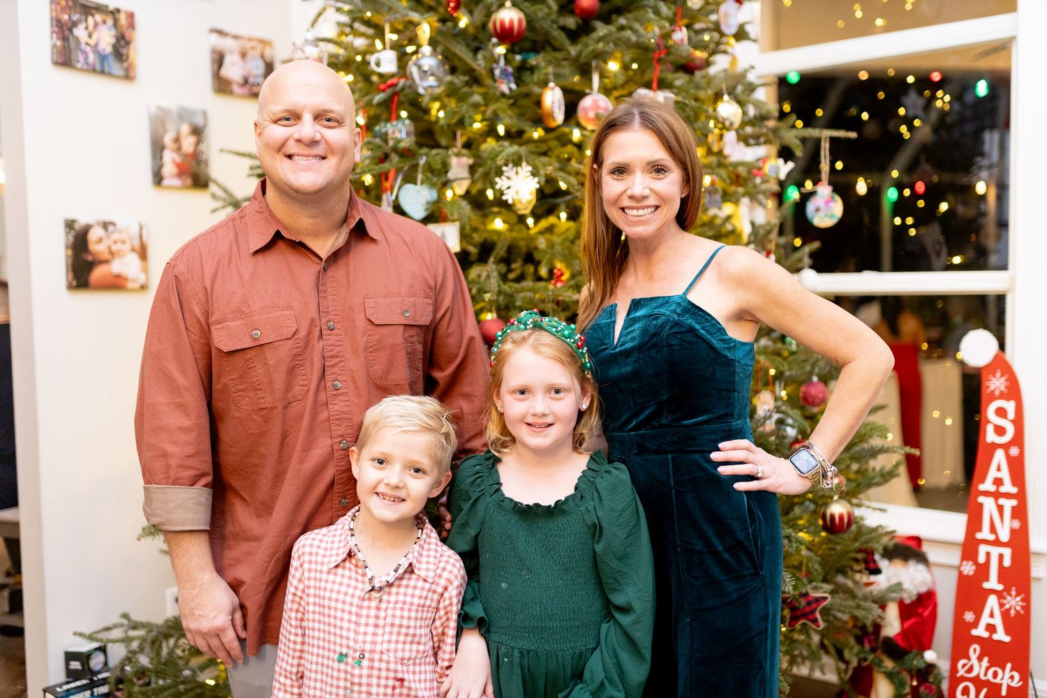 Festive family gathering by illuminated Christmas tree with coordinated holiday attire.