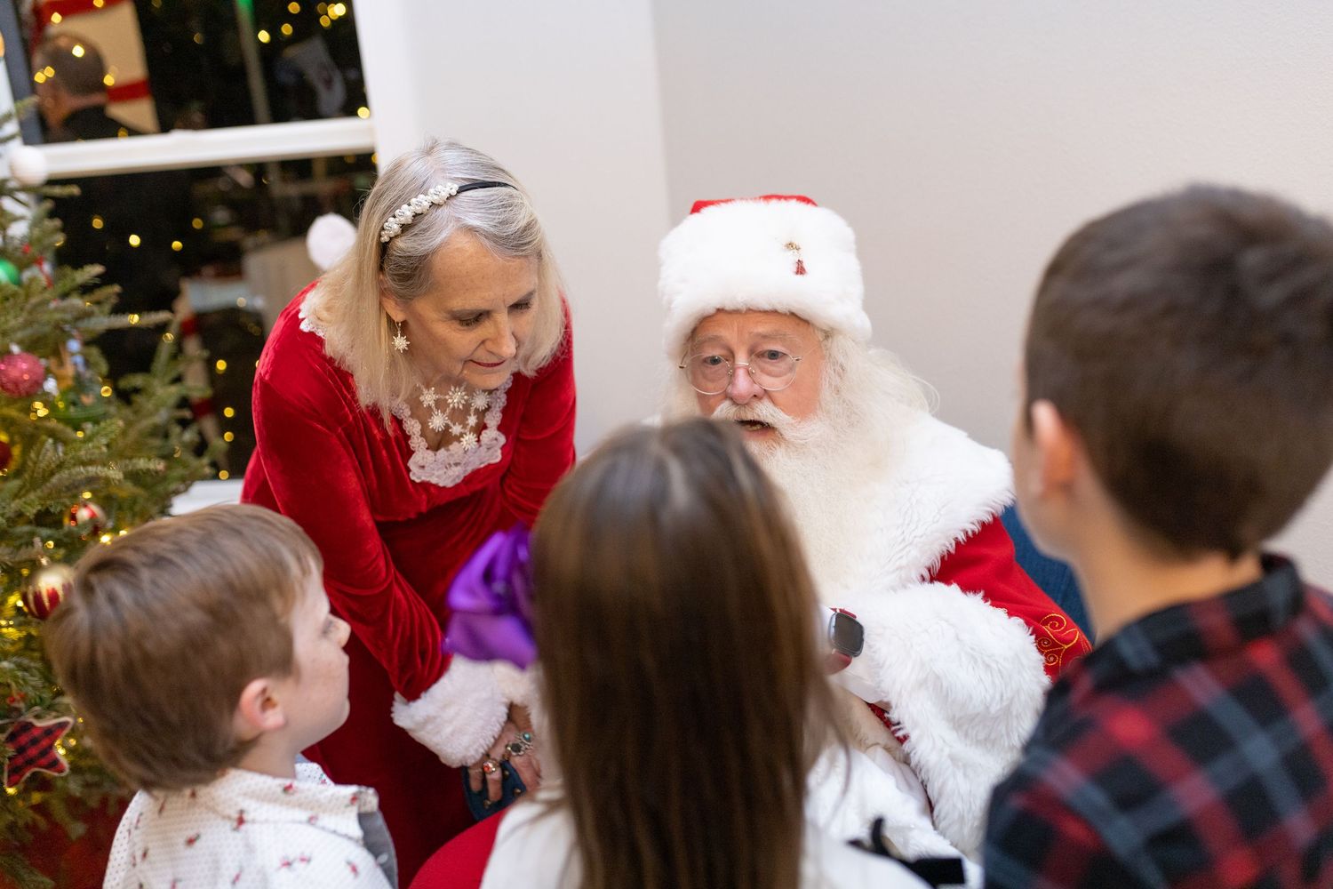 A Christmas gathering in a cozy living room with Santa Claus and holiday decorations.