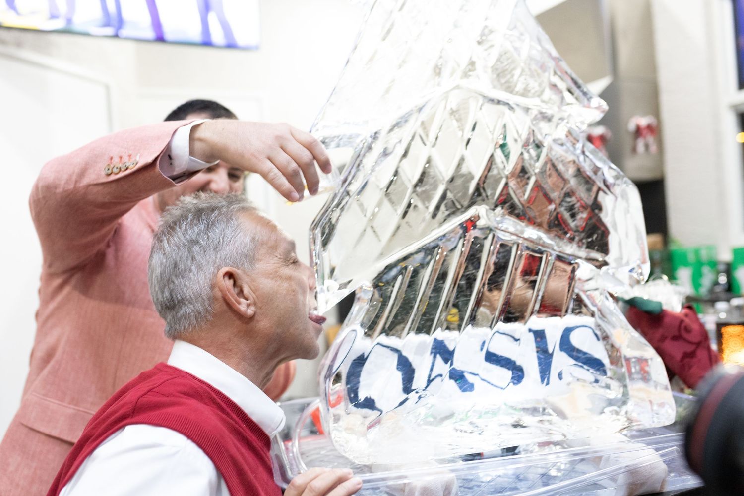People gathered around a decorative ice sculpture at an elegant holiday celebration.
