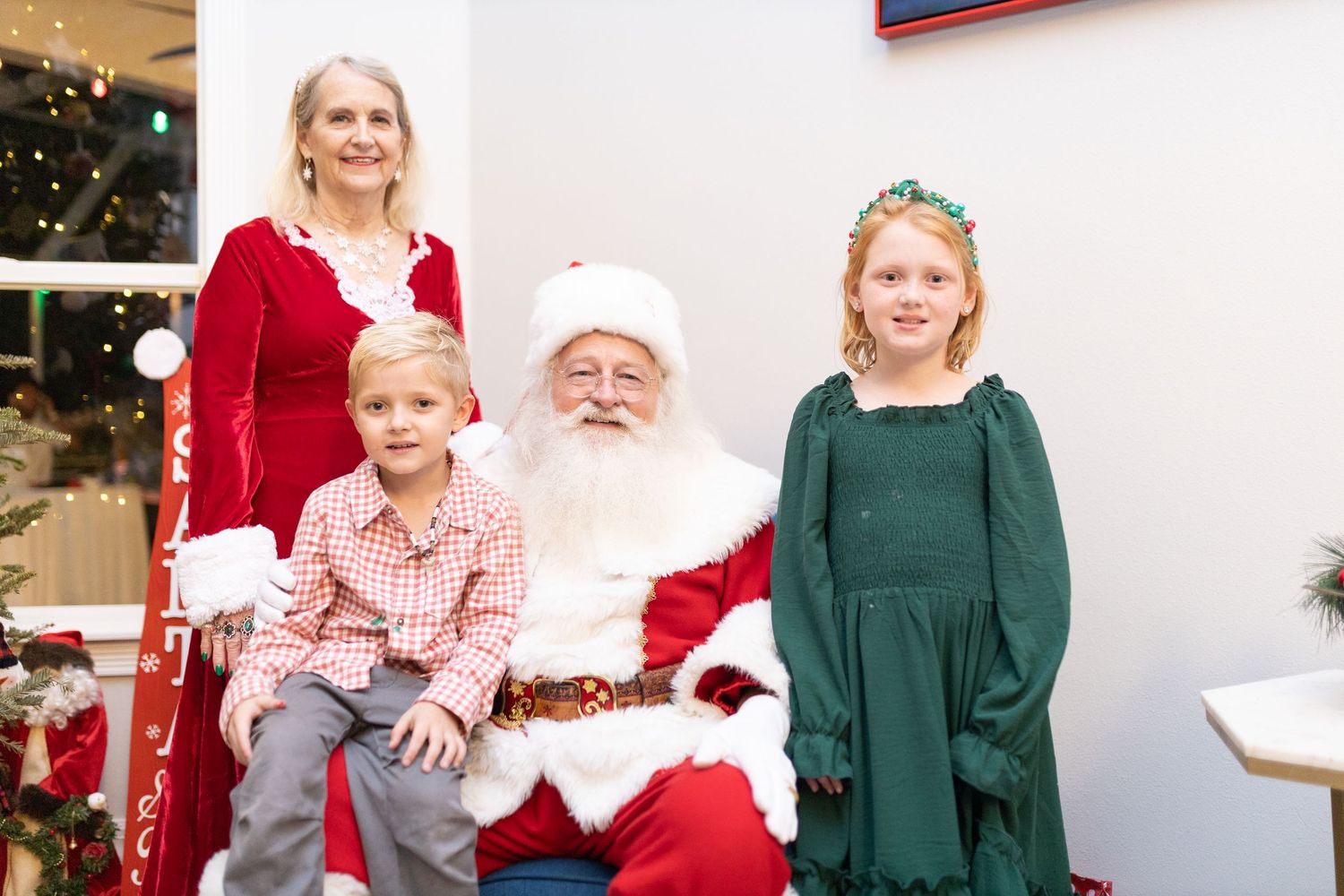 Holiday photo setting with Christmas tree, blue chair and seasonal decorations.