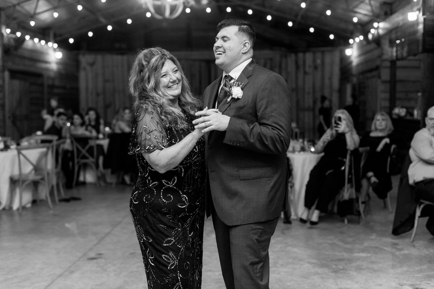 Couples dancing together during an evening wedding reception under twinkling lights.