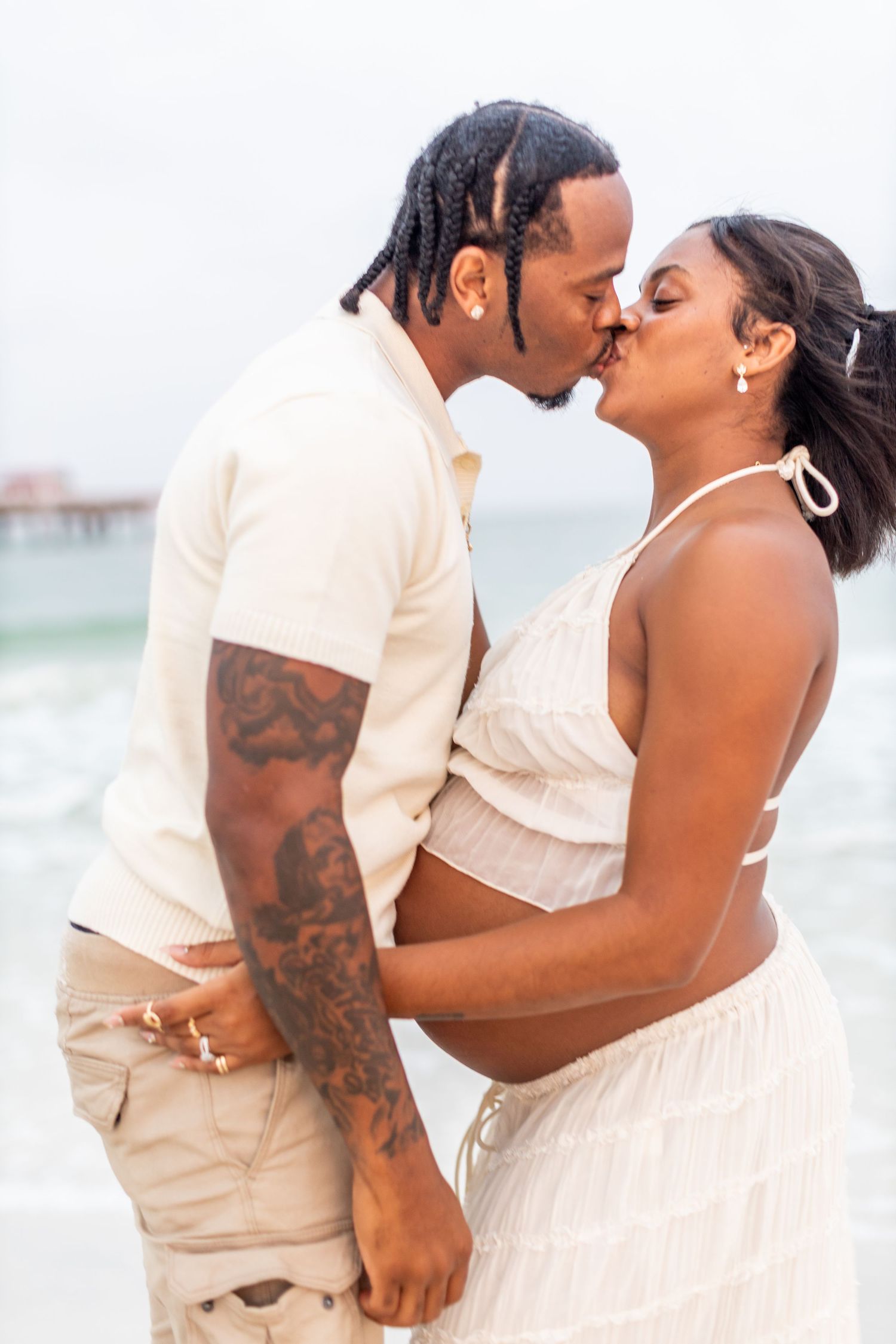 A romantic beach photoshoot captures an intimate moment between a couple.