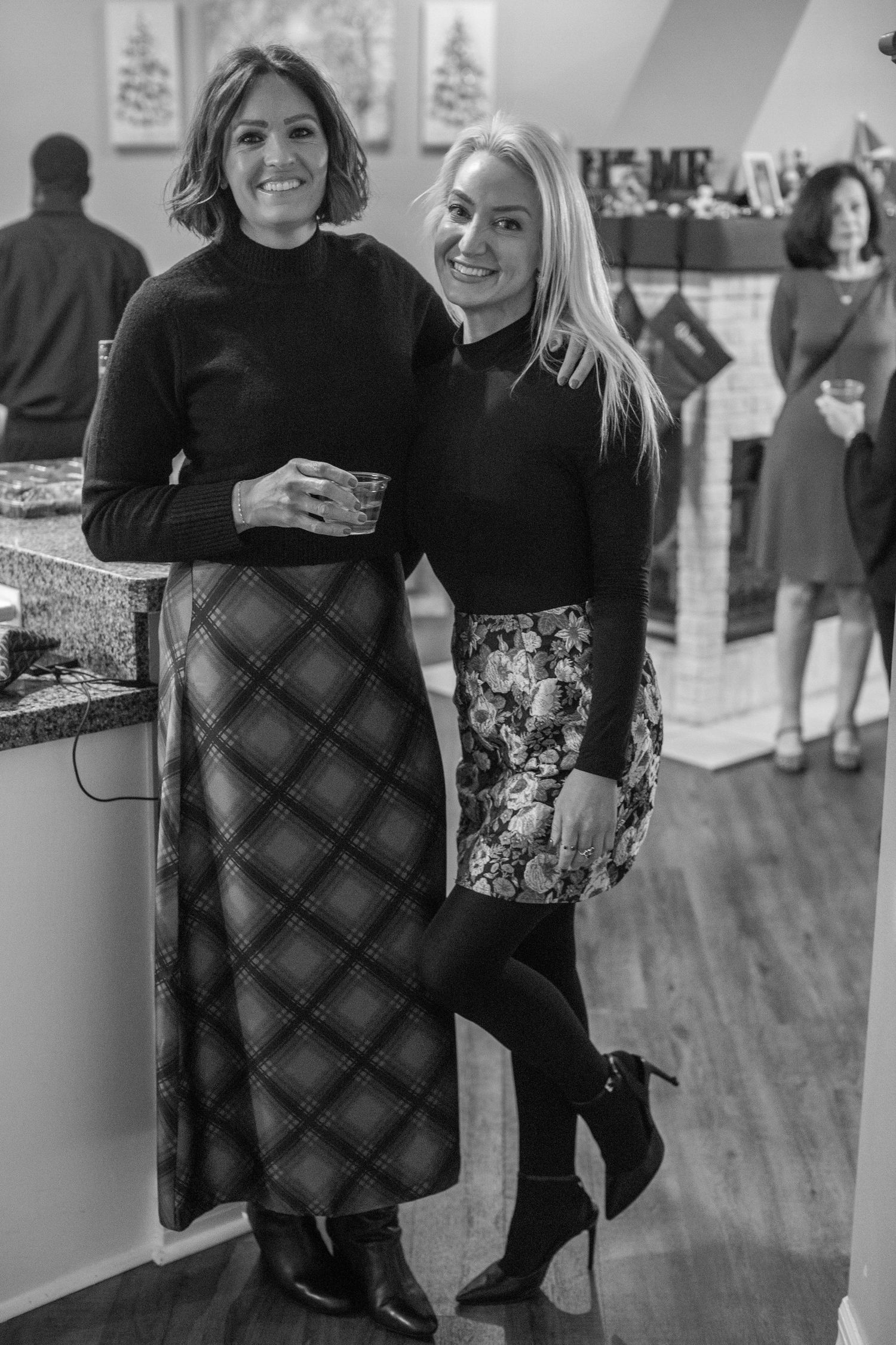 People in festive winter attire posing at a holiday gathering.
