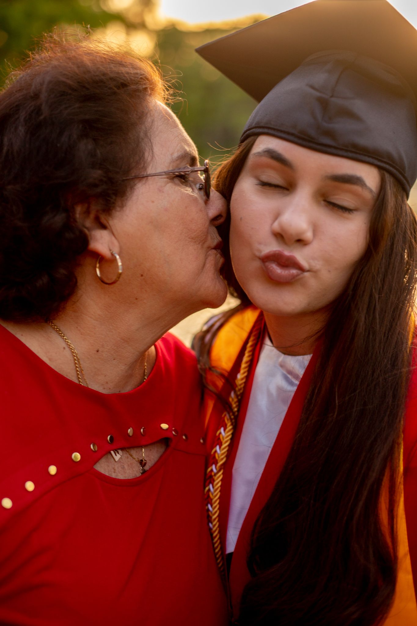 Intimate moment between graduate and loved one during sunset photo session.