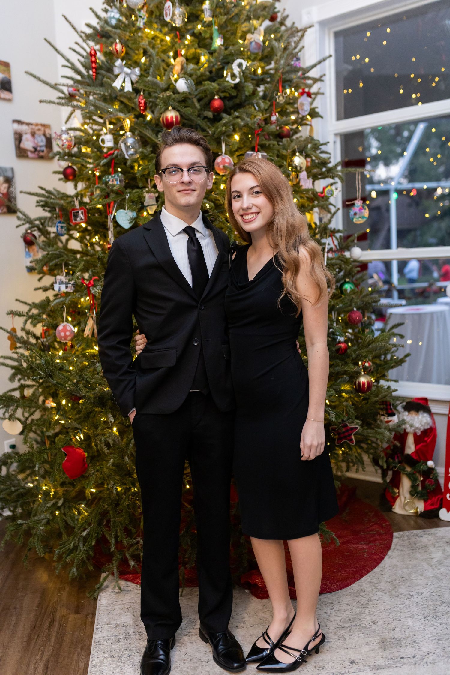Decorated Christmas tree with lights provides backdrop for formal holiday celebration.