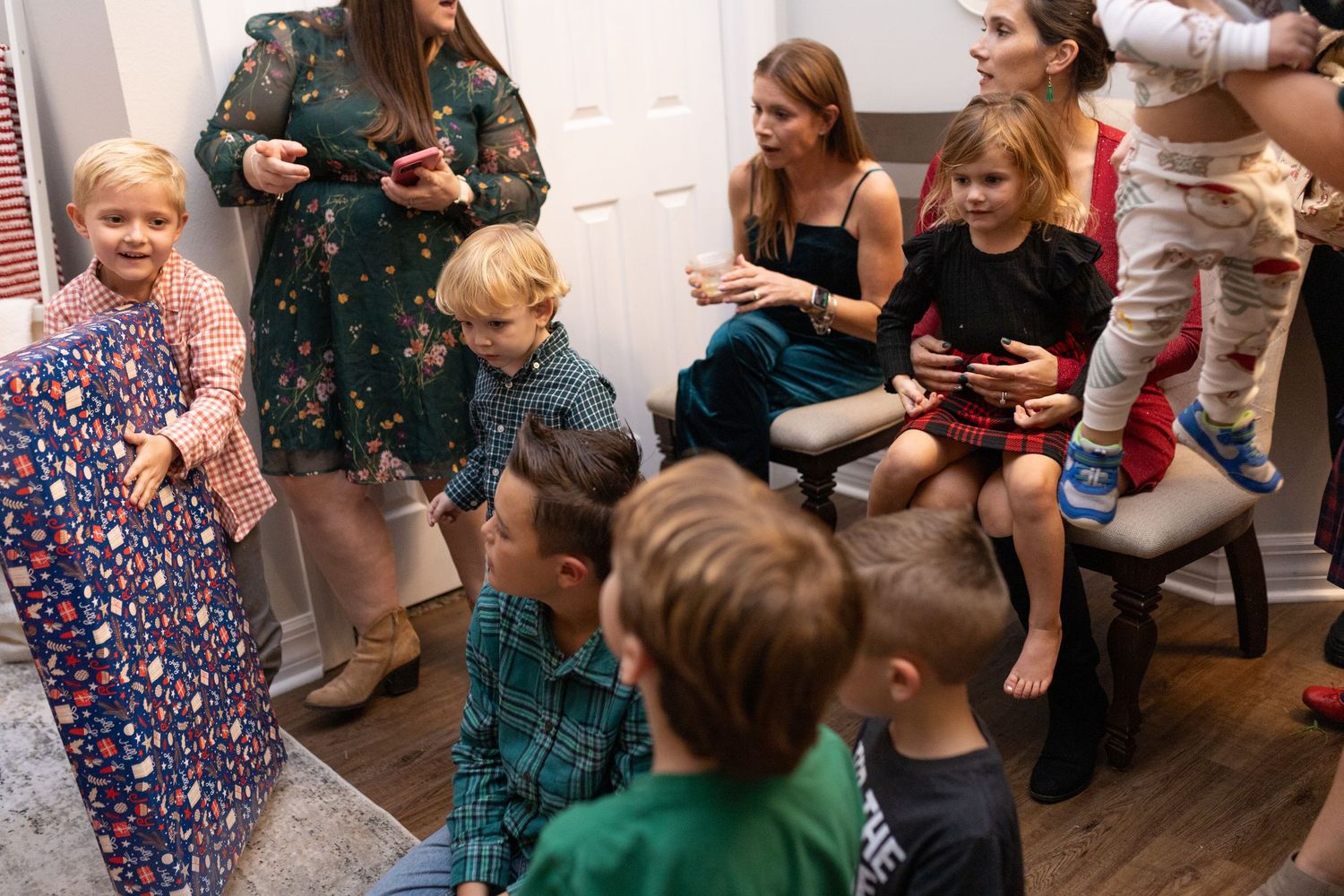 People socializing at a Christmas party with decorated interior and festive atmosphere.