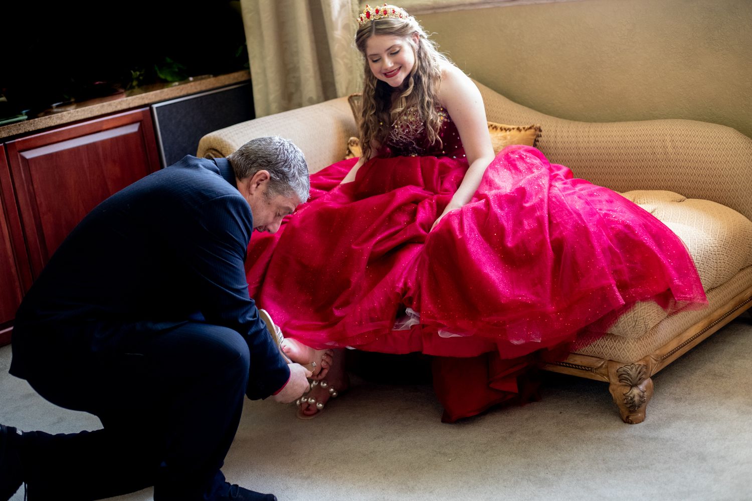 Behind the scenes photo shoot with red formal gown on indoor set.