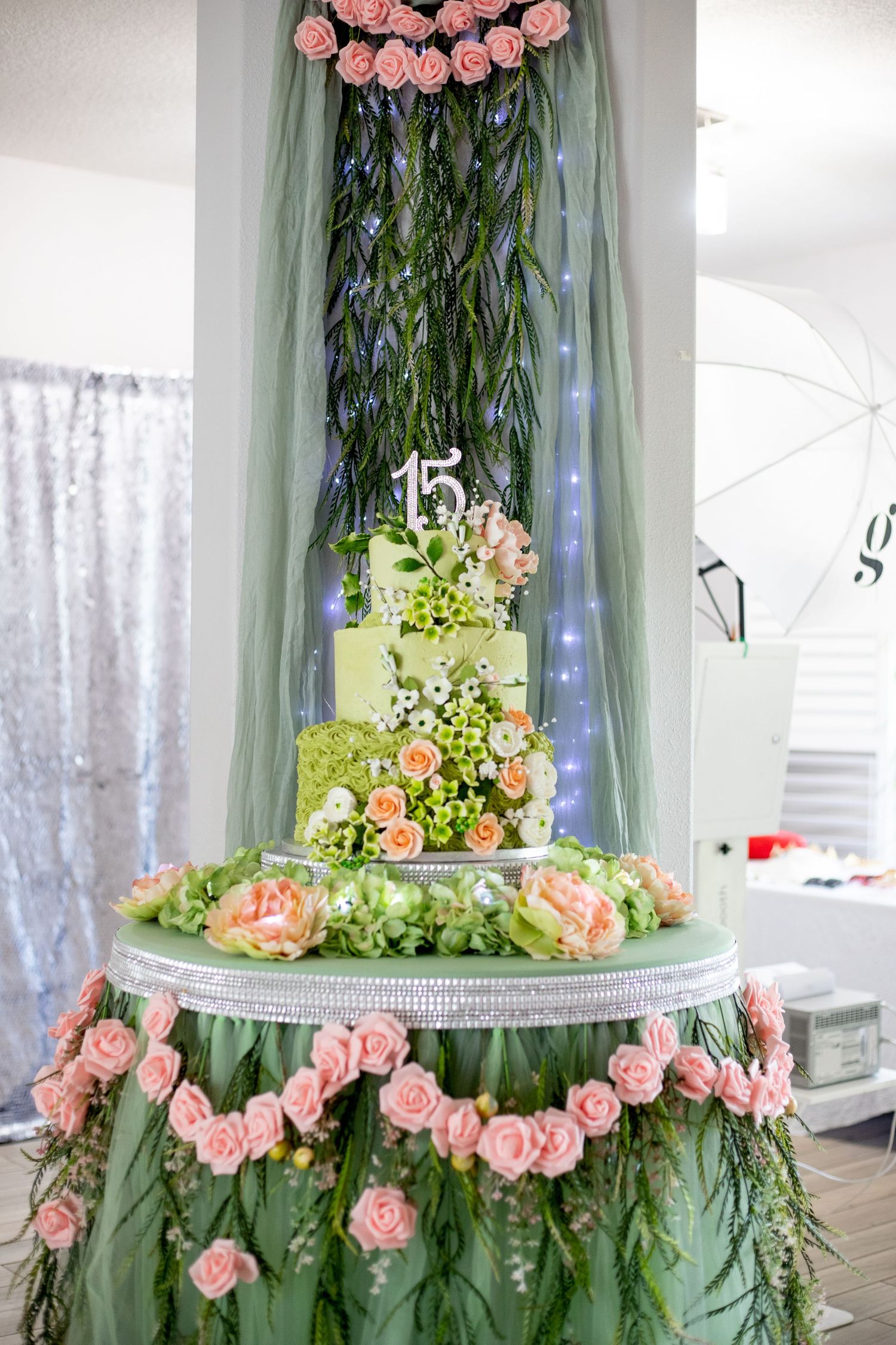 Pink roses and greenery decorate a tiered display stand for an elegant party setup.