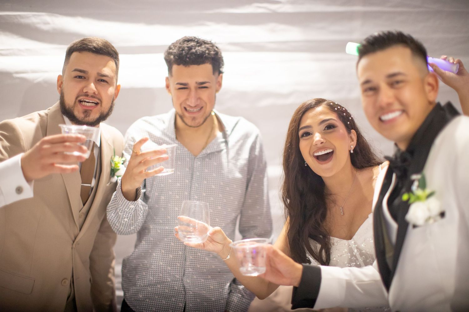 Wedding guests raise glasses in a celebratory toast at a reception.