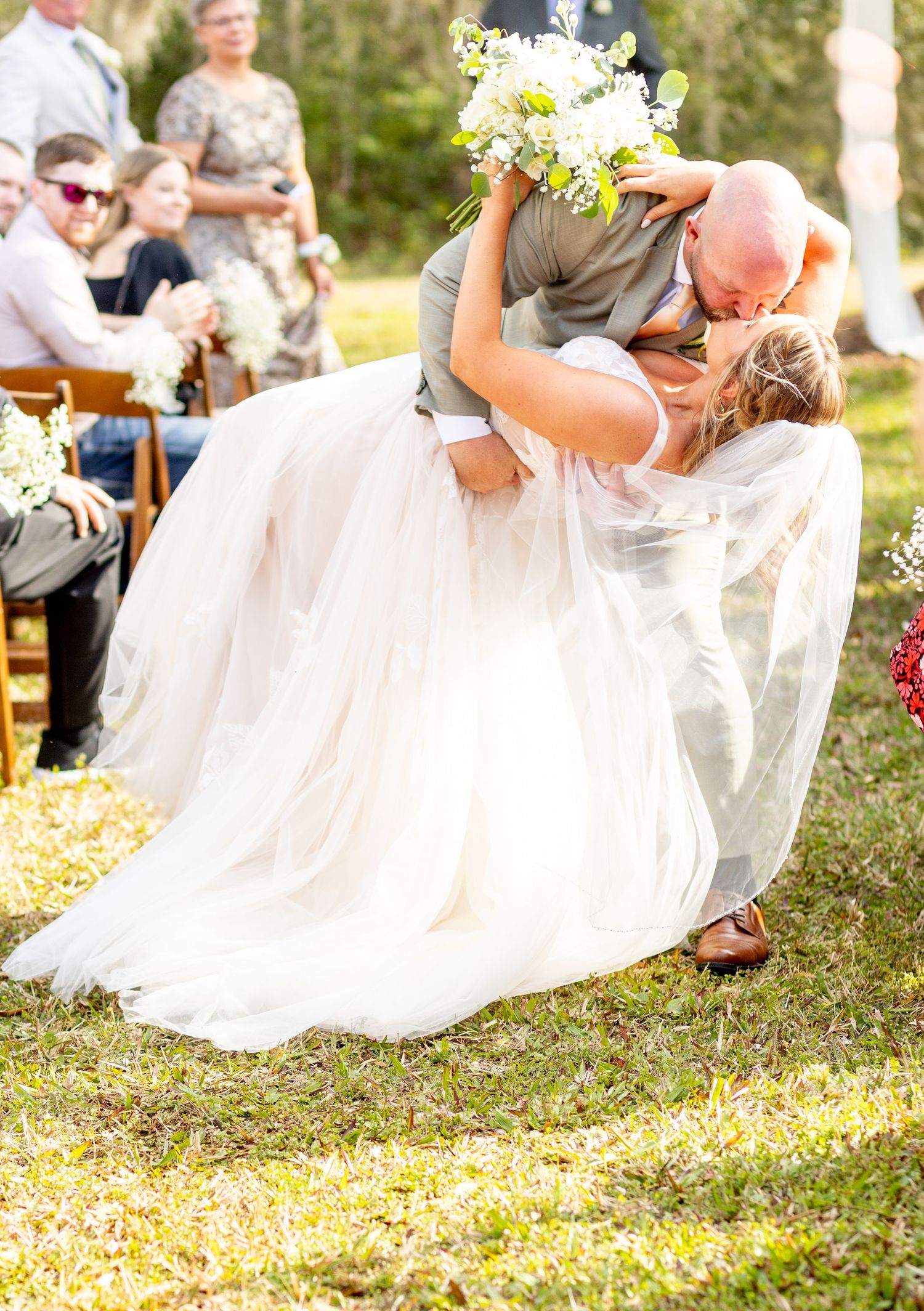 White wedding dress flowing in the breeze during an outdoor celebration.