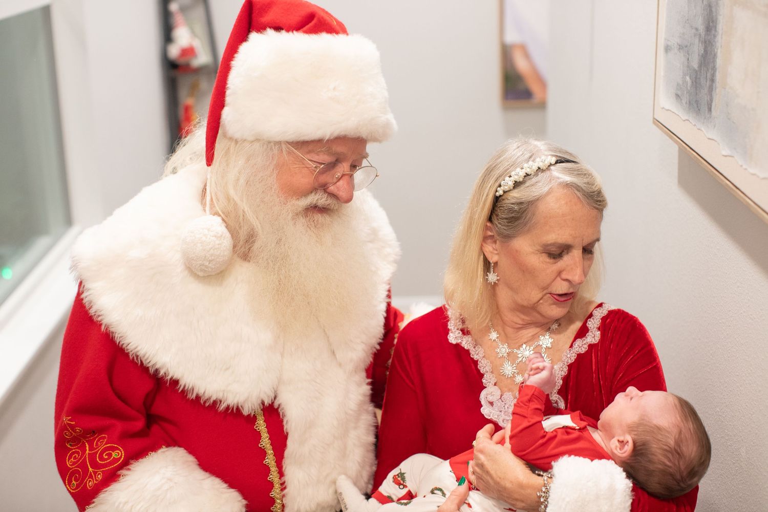 A festive holiday scene with Santa Claus meeting with children and families.