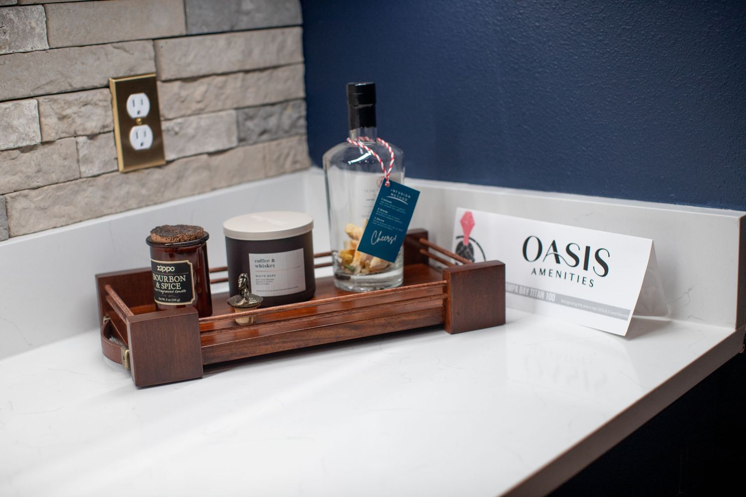 Modern bathroom counter with white surface and wooden organizer displaying Oasis branded products.