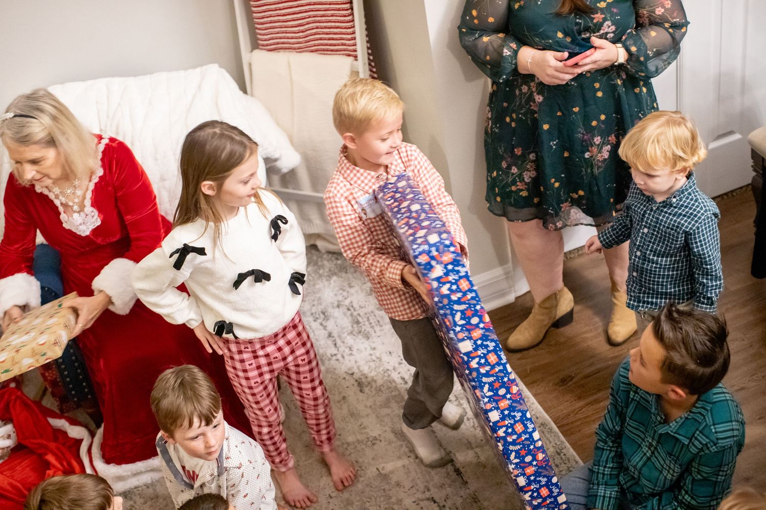 Children and adults enjoying a Christmas party with Santa in a decorated room.