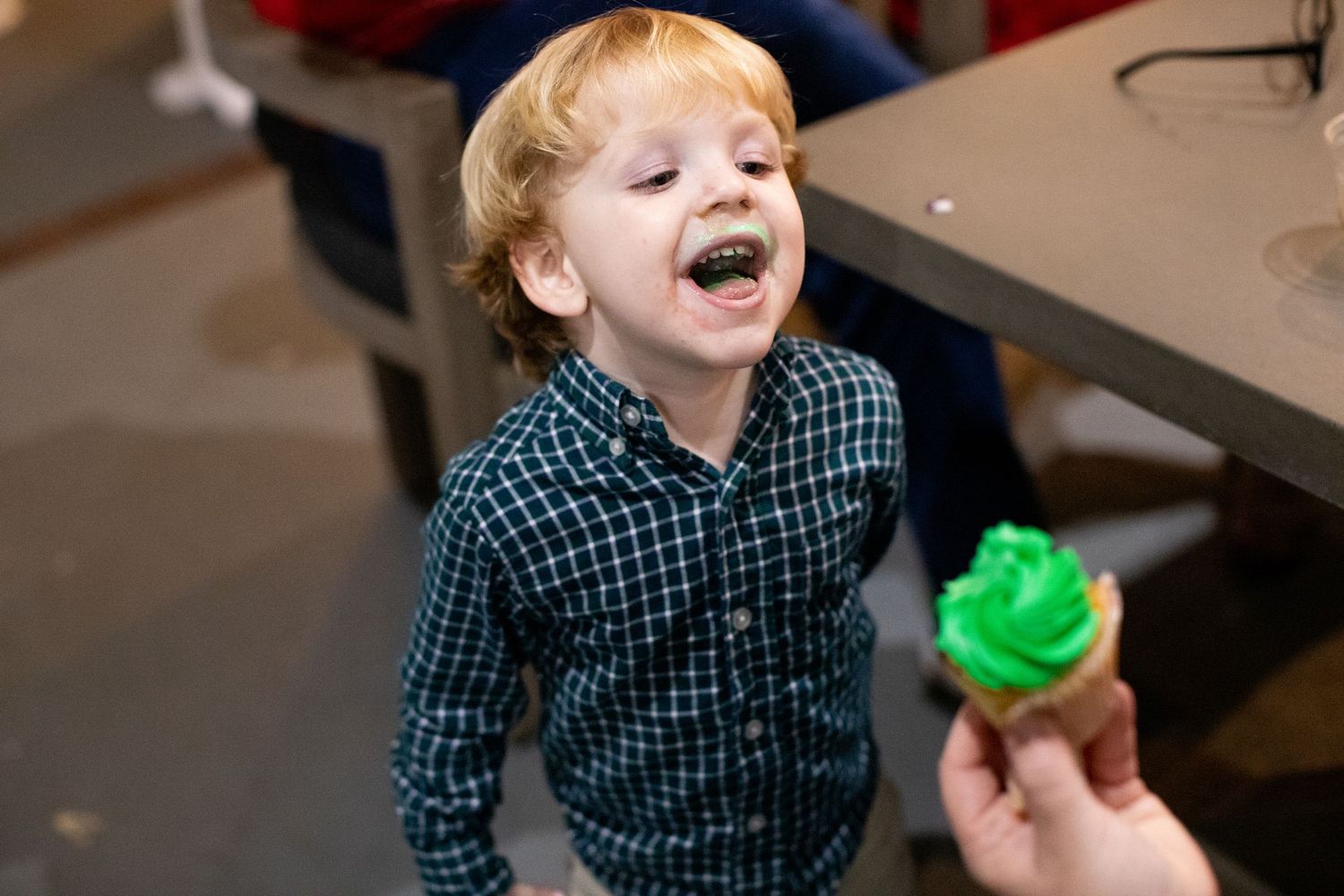 Child in plaid shirt showing expressions of joy and excitement during holiday festivities.