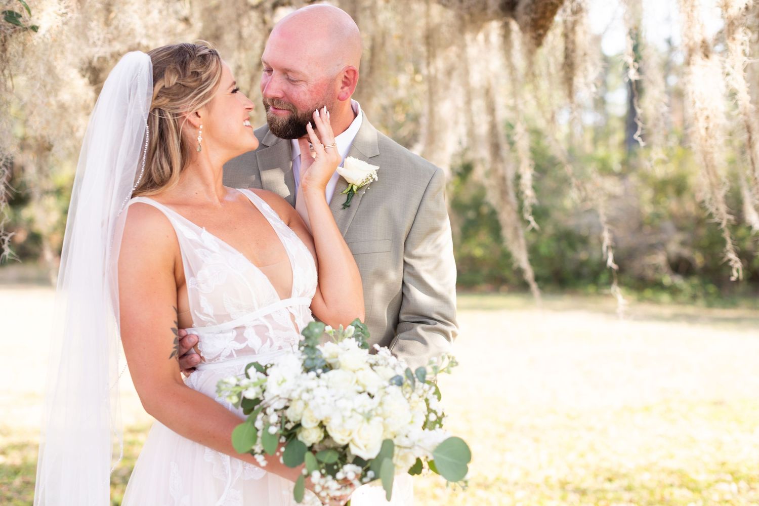Wedding portraits captured in dreamy outdoor setting with natural light filtering through trees.