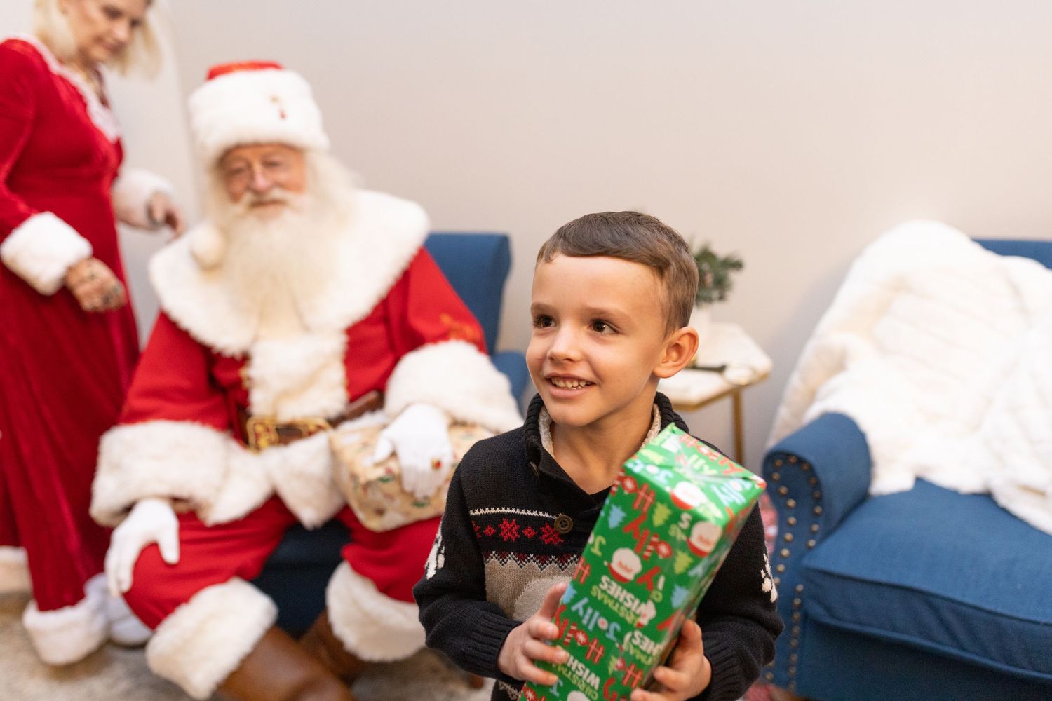 Children receive gifts from Santa Claus during a festive Christmas celebration.