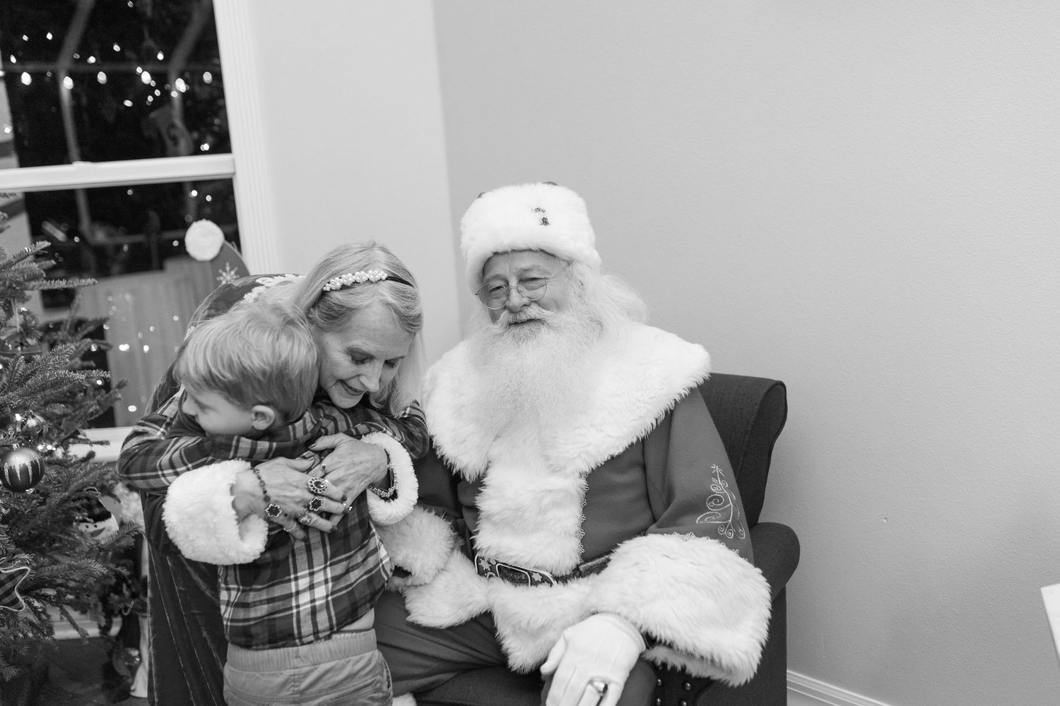 Black and white holiday photo with Santa Claus and Christmas decorations.