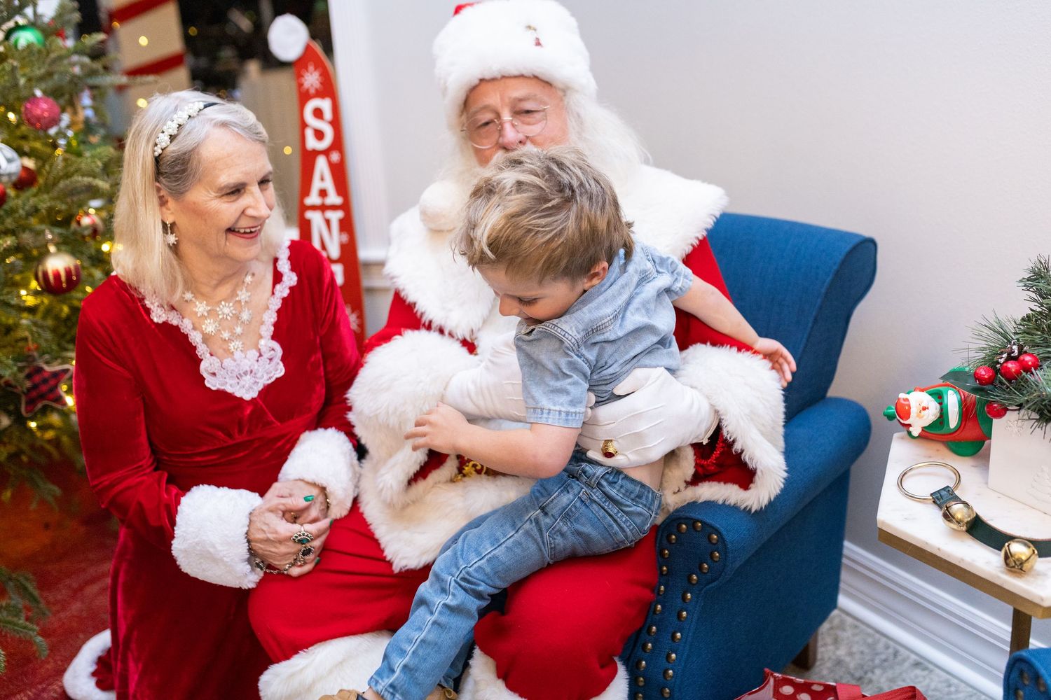 Holiday photo session showing playful moments with Christmas decorations in background.